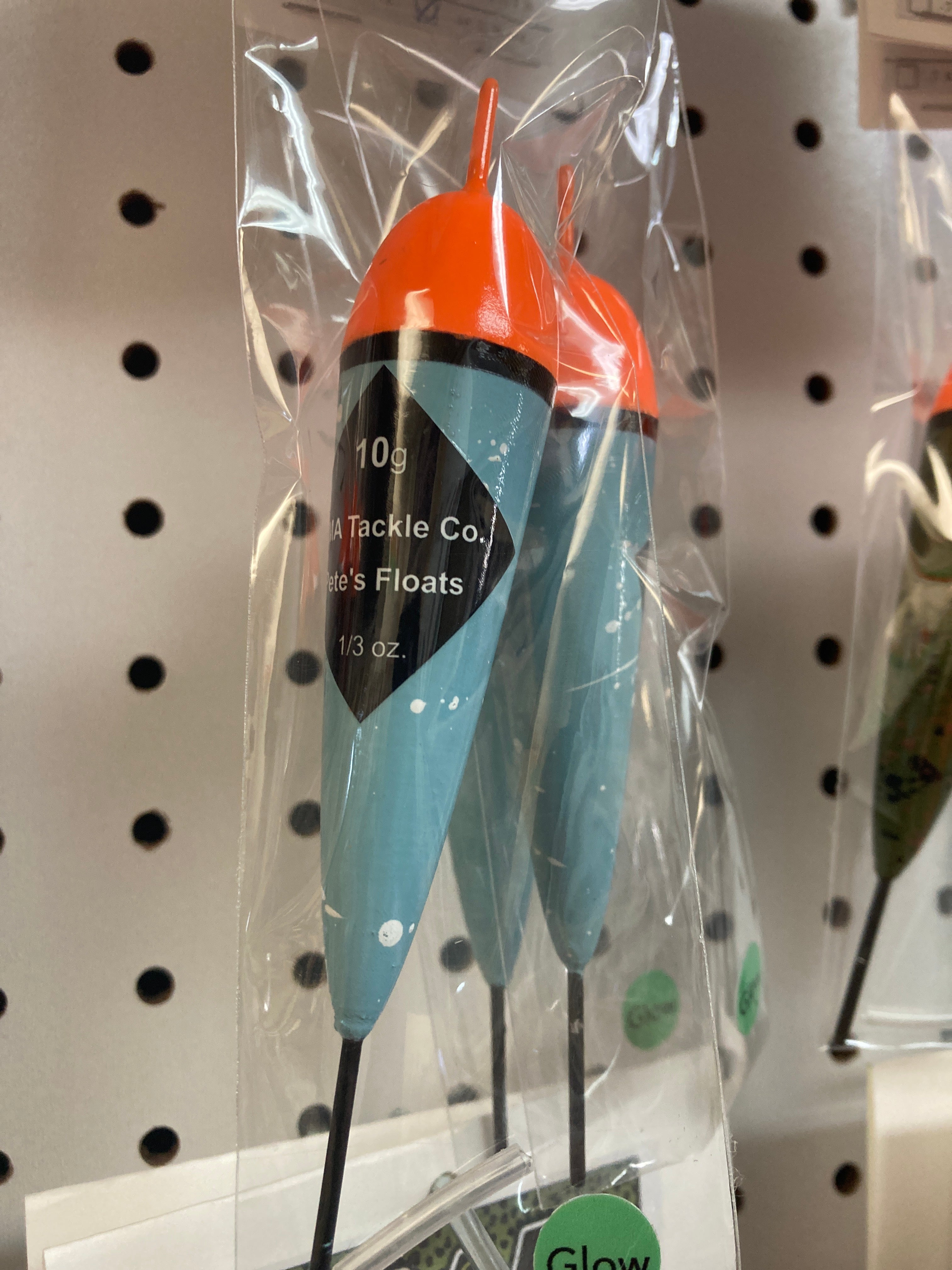 Fishing float in clear bag, orange cap with black band, blue body