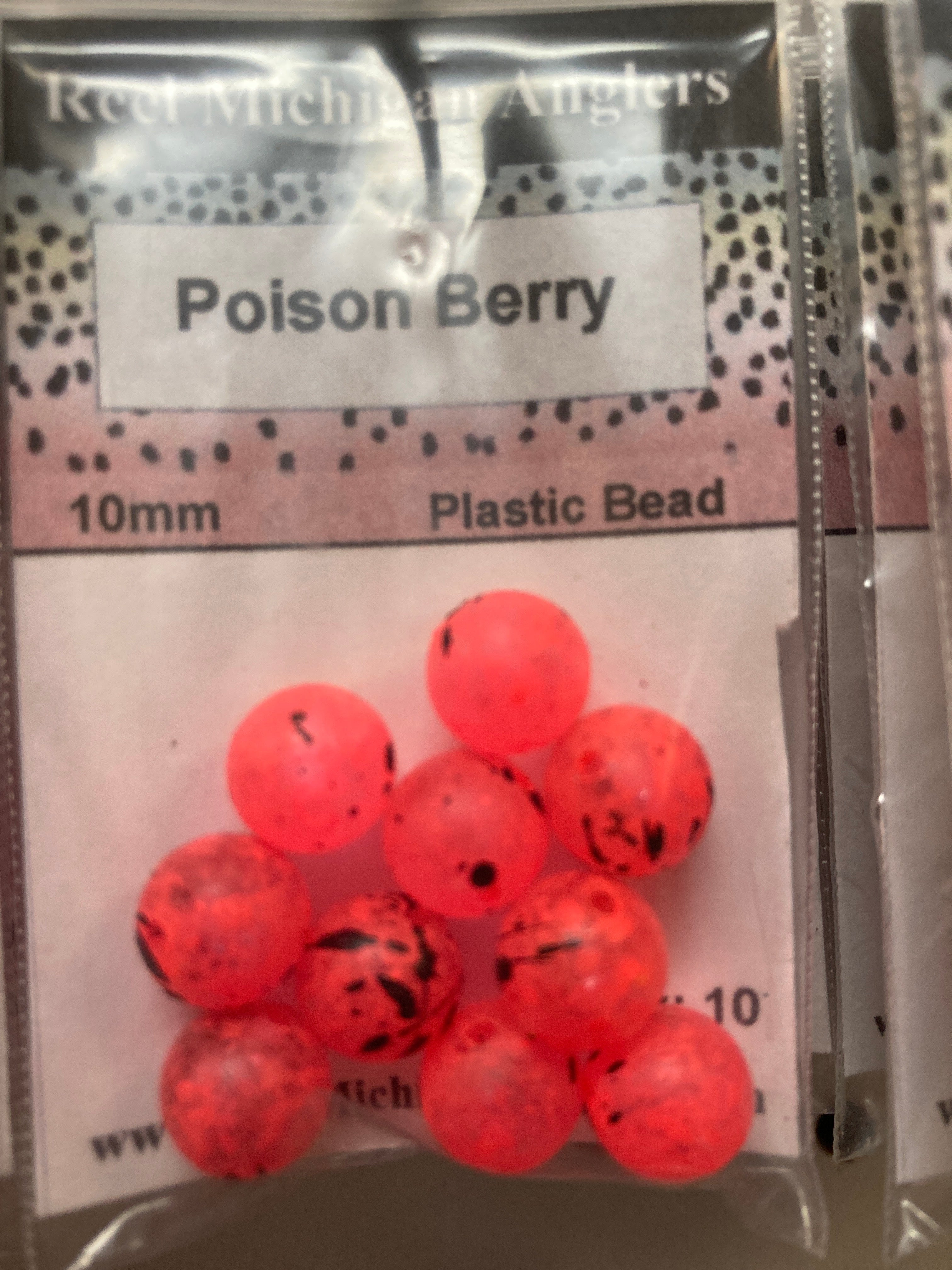 Red plastic bead pack with round beads and black speckles, 10mm label visible