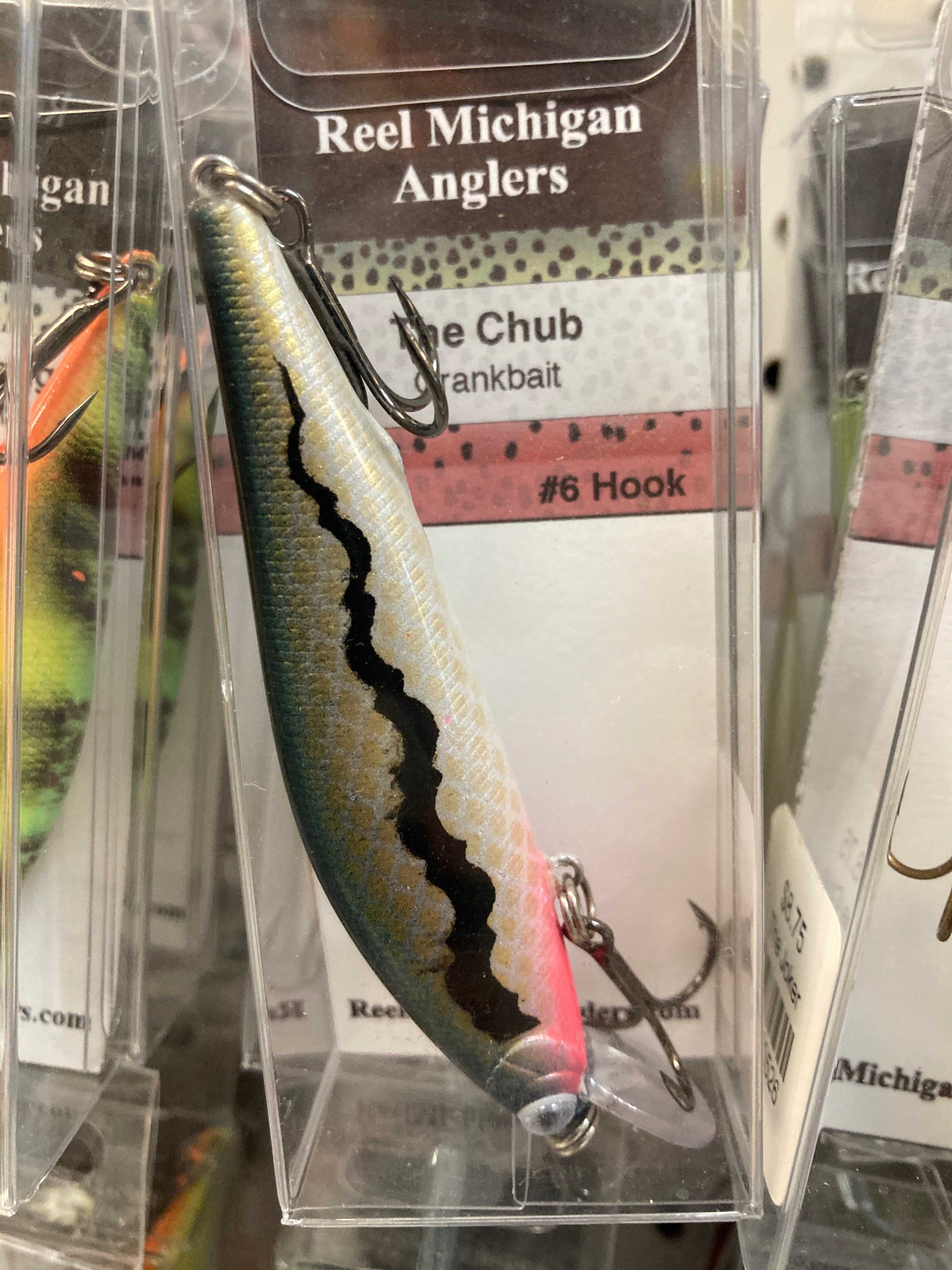 Fishing lure with silvery blue scale finish, dark stripe, and treble hook
