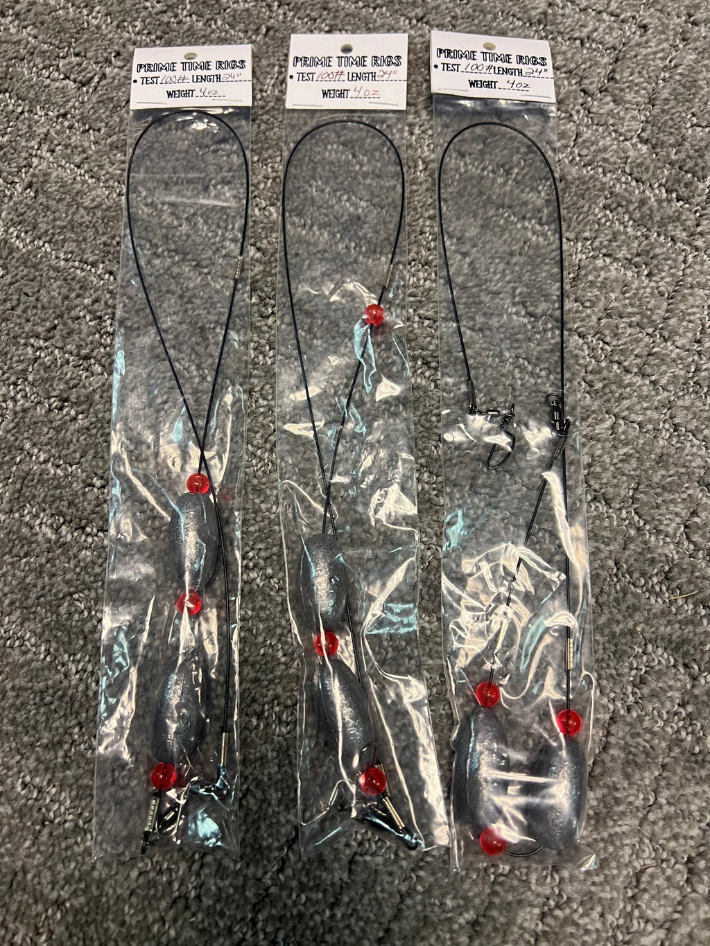 Set of Carolina rig leaders with split hooks and red beads on dark line, in bag
