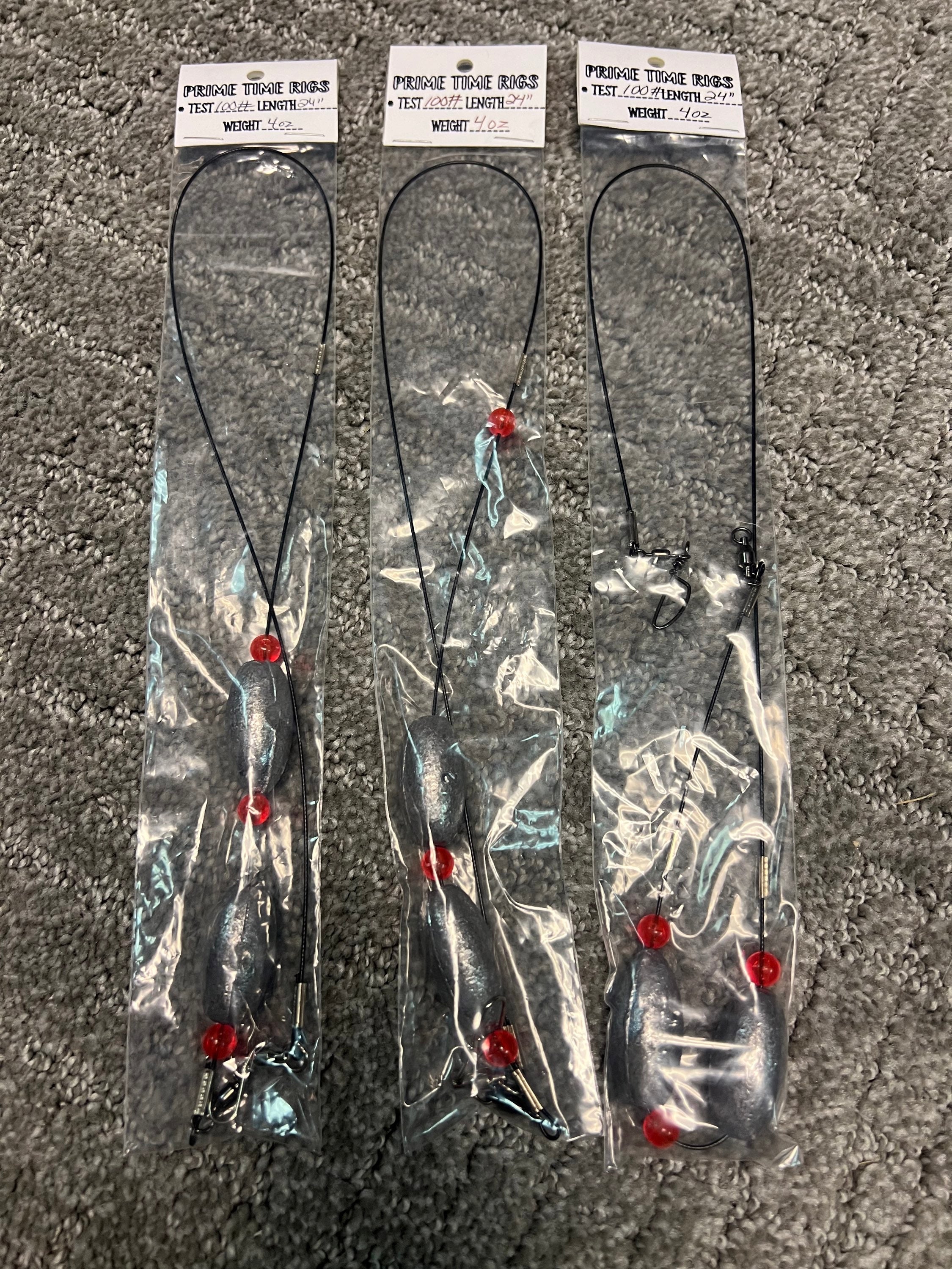 Set of Carolina rig leaders with split hooks and red beads on dark line, in bag