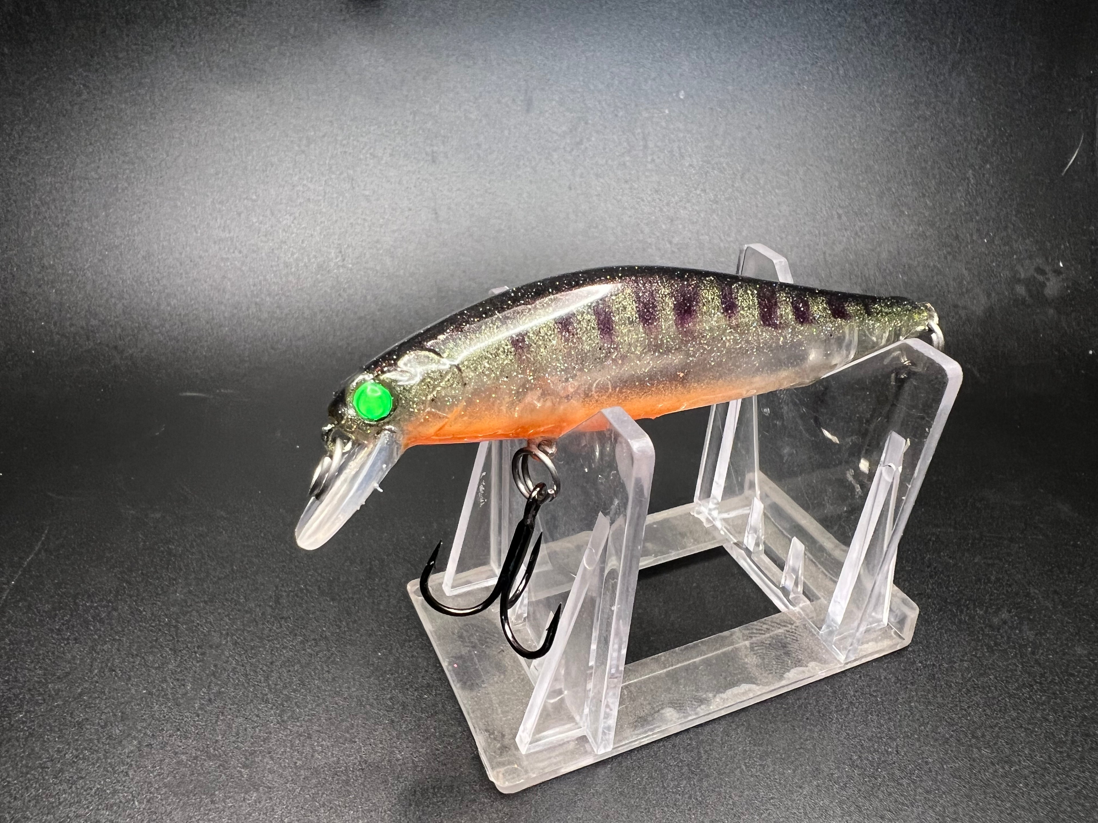 The Perchinator Clickbait UV jerkbait, 3.5 in 1/4 oz, orange with green eye