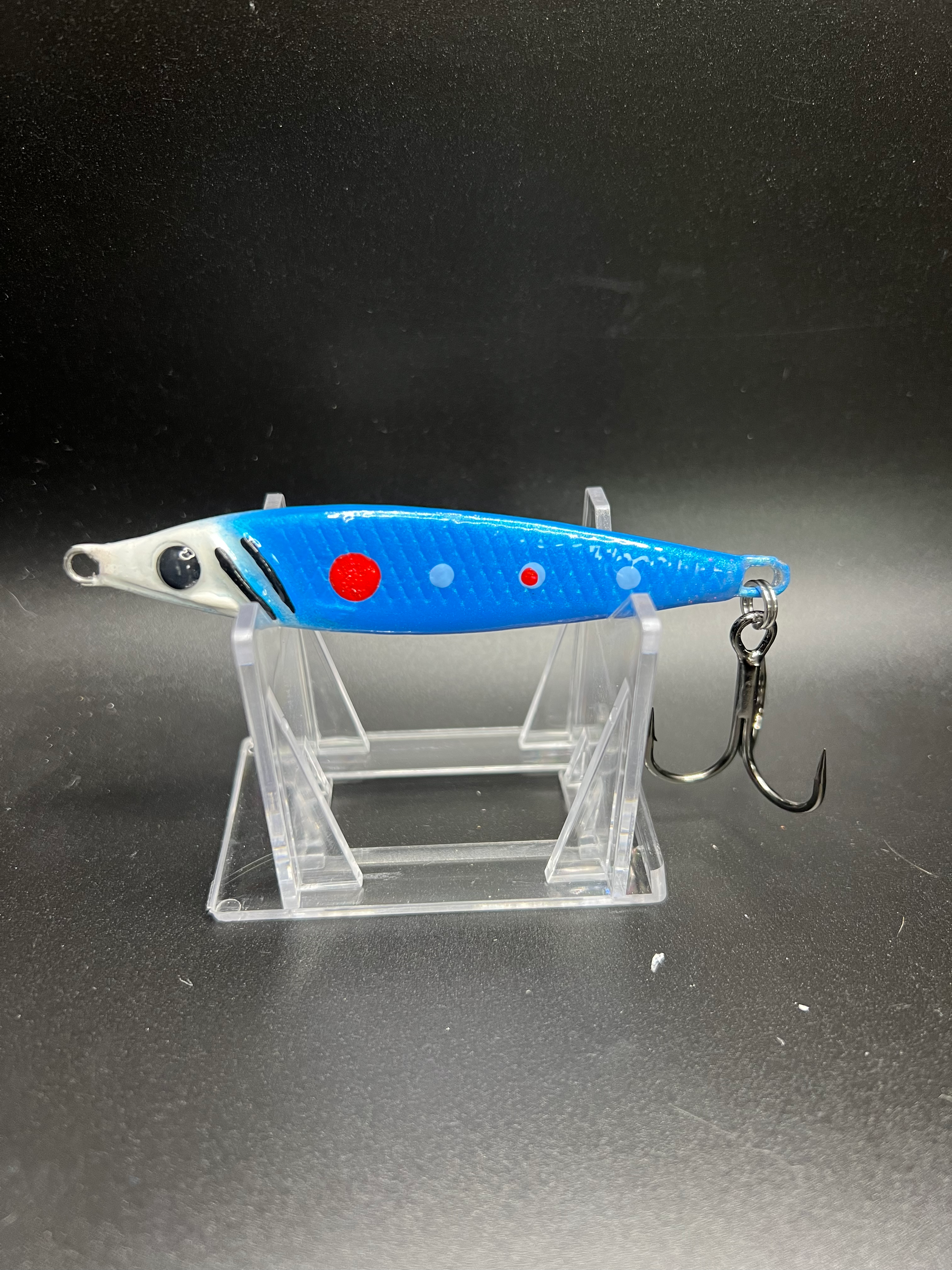 Jigging spoon lure, blue body with red dots and black eye, silver ends, double hooks