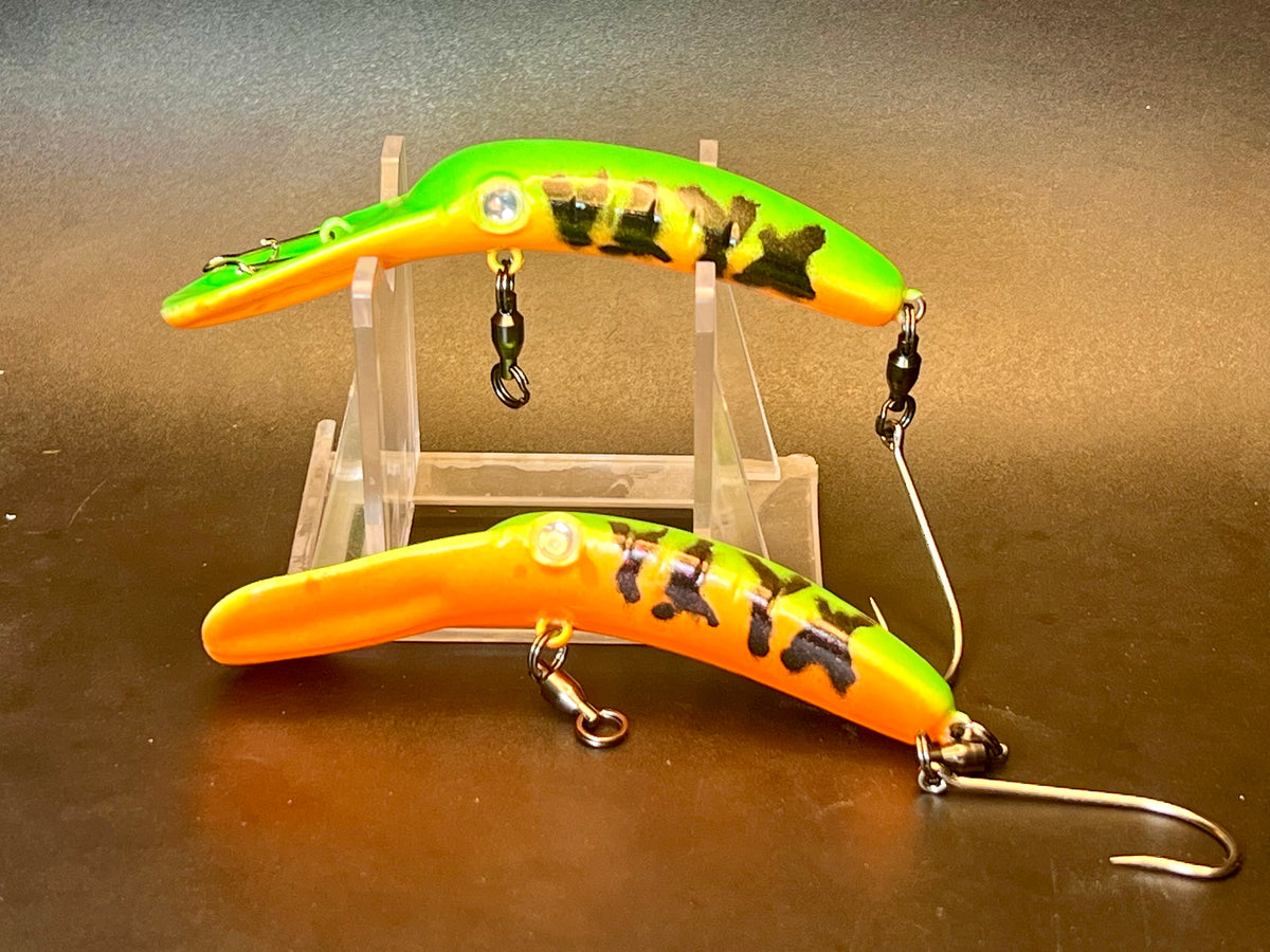 Two orange and yellow fishing lure plugs with black tiger stripes, hooks and split rings