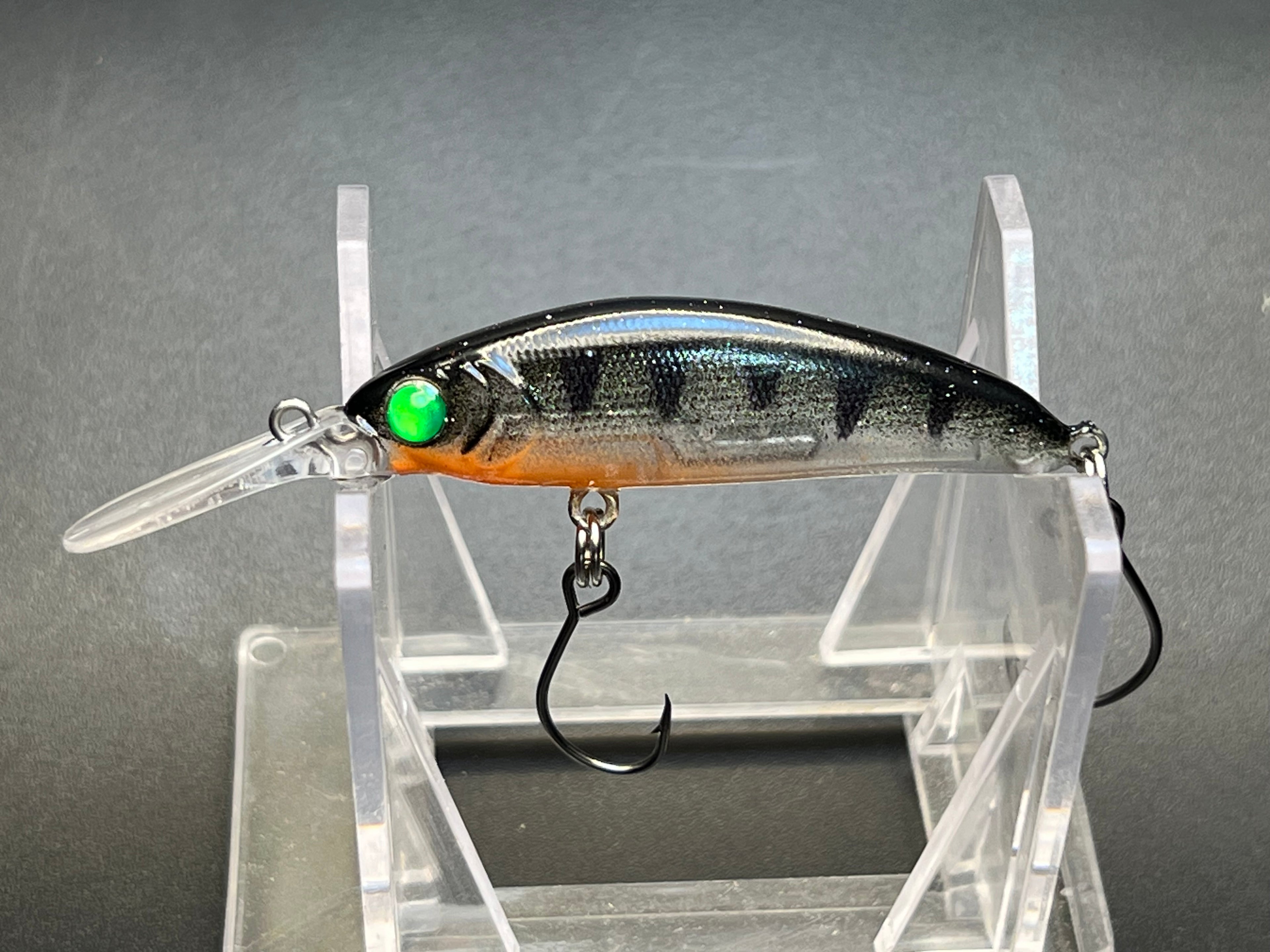 Micro deep sinking jerkbait with silver-blue body, green eye, orange stripe, treble hook