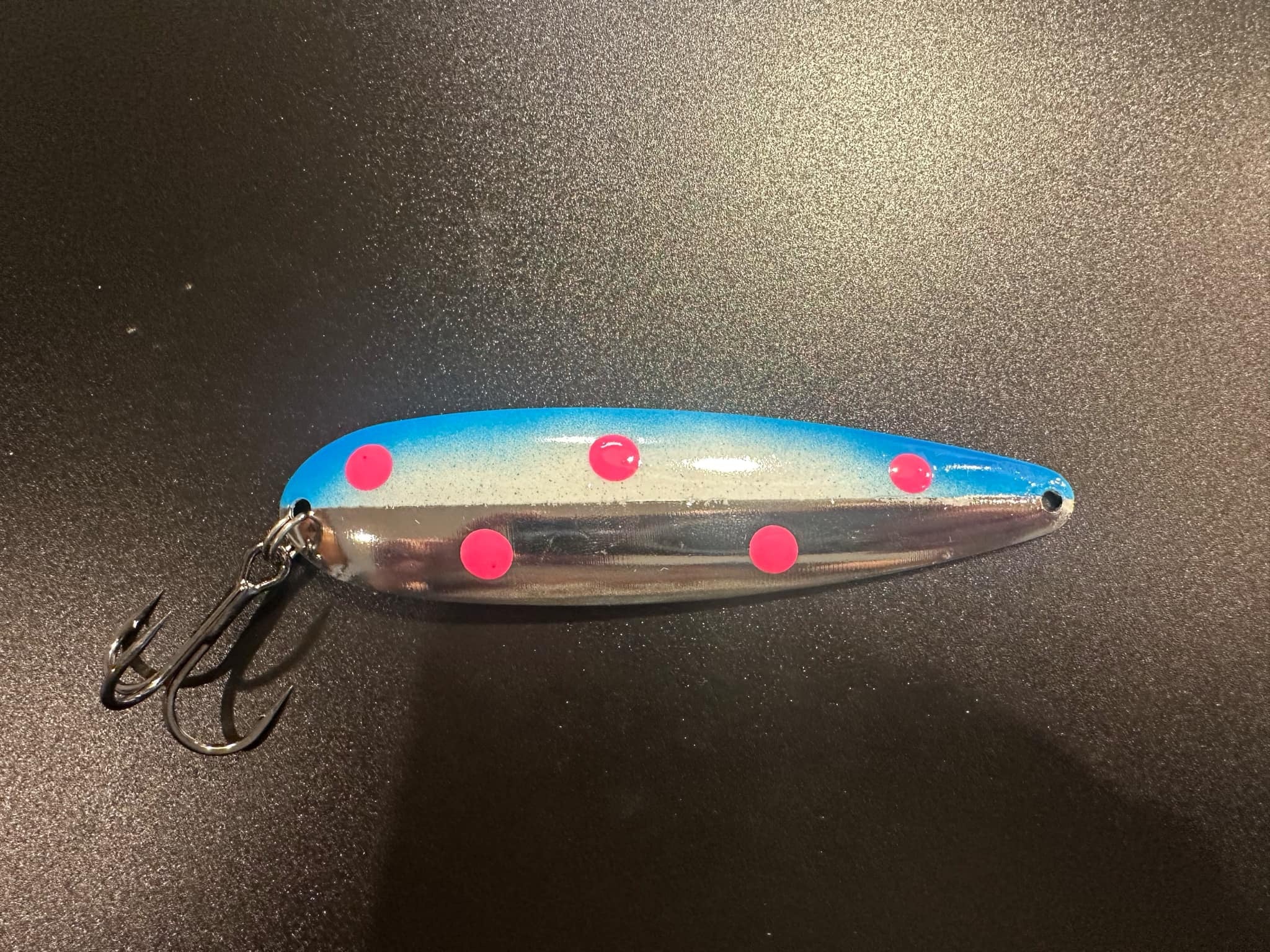 Pluto trolling spoon lure with blue top, silver body, pink dots, and treble hooks