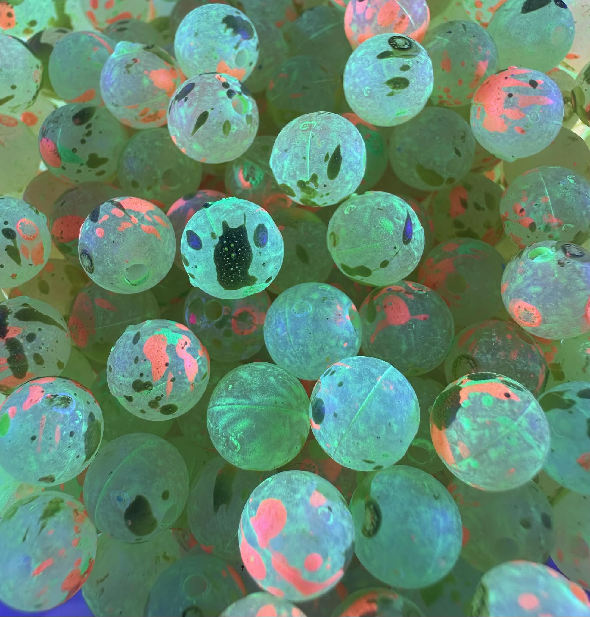 UV-glow fishing beads, turquoise-green with orange spots and dark dot specks