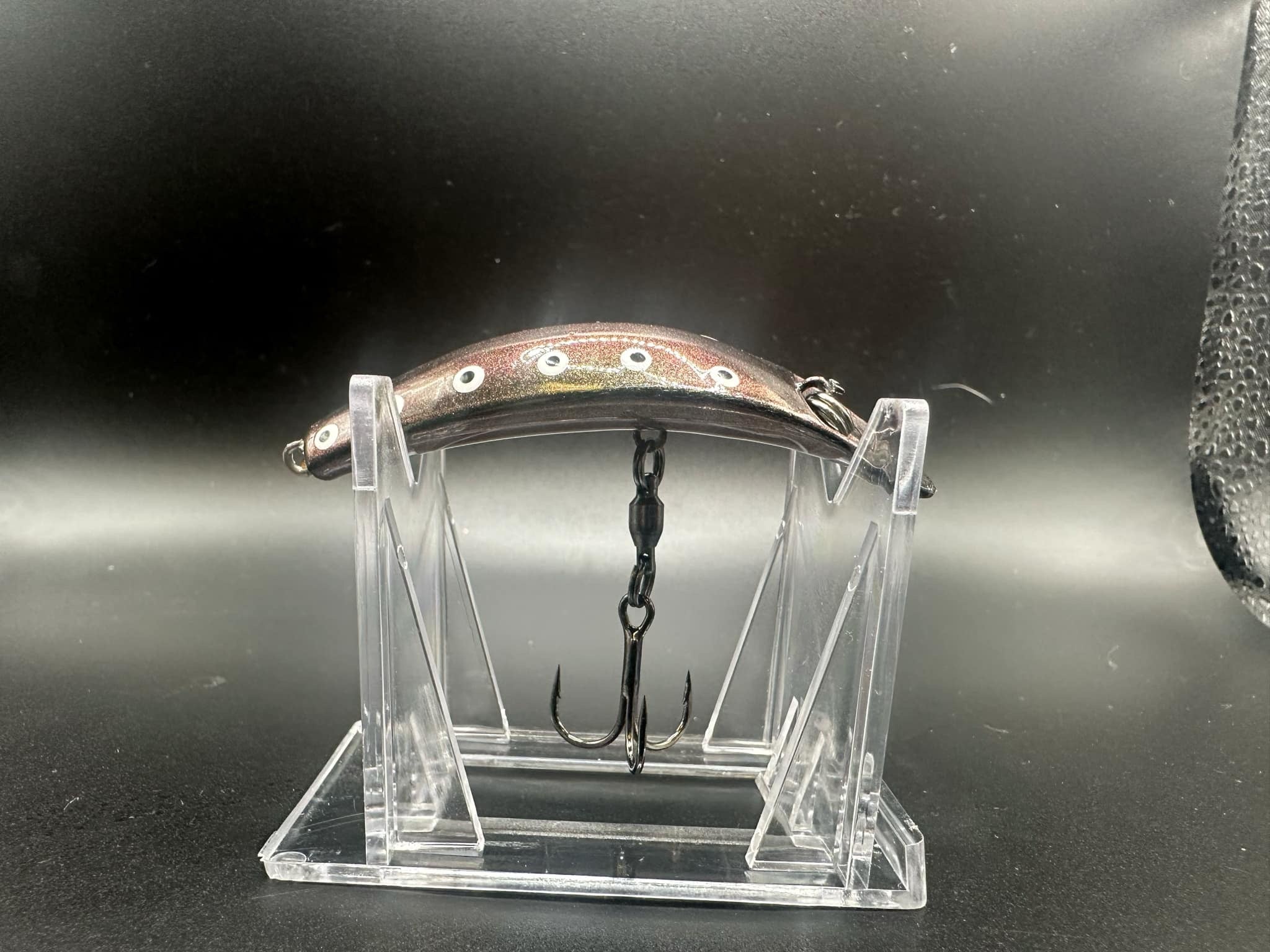 Jeremiah UV Swiftfish lure on clear stand, brown top with white spots and metal hooks