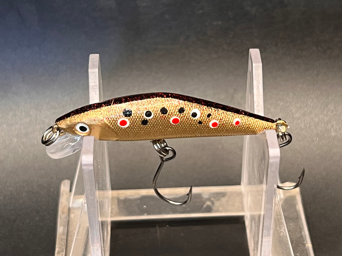 Gold trout-pattern sinking jerkbait with diving lip and two treble hooks