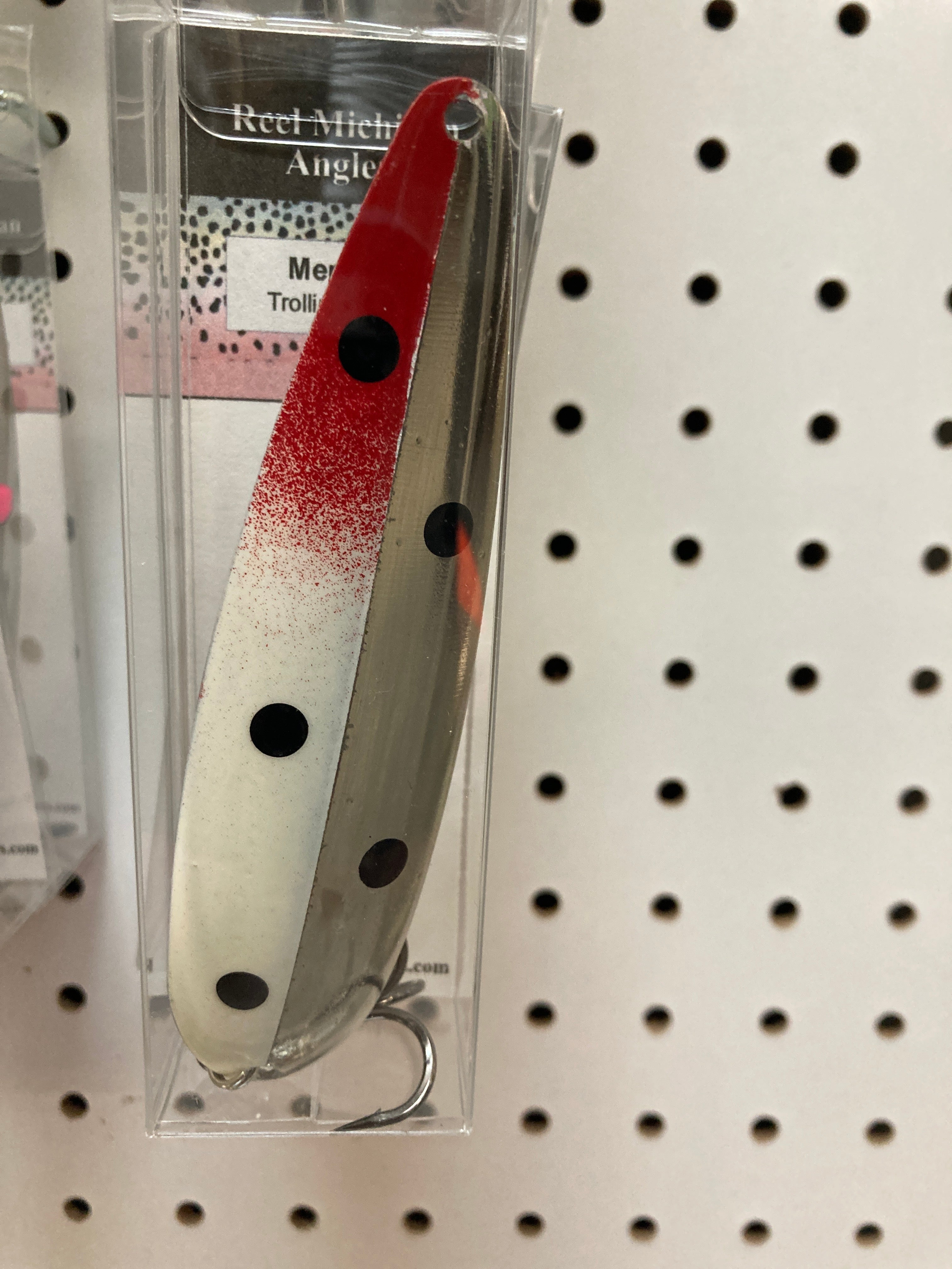 Two-tone trolling spoon lure with red and white body, black spots, and wire hook.