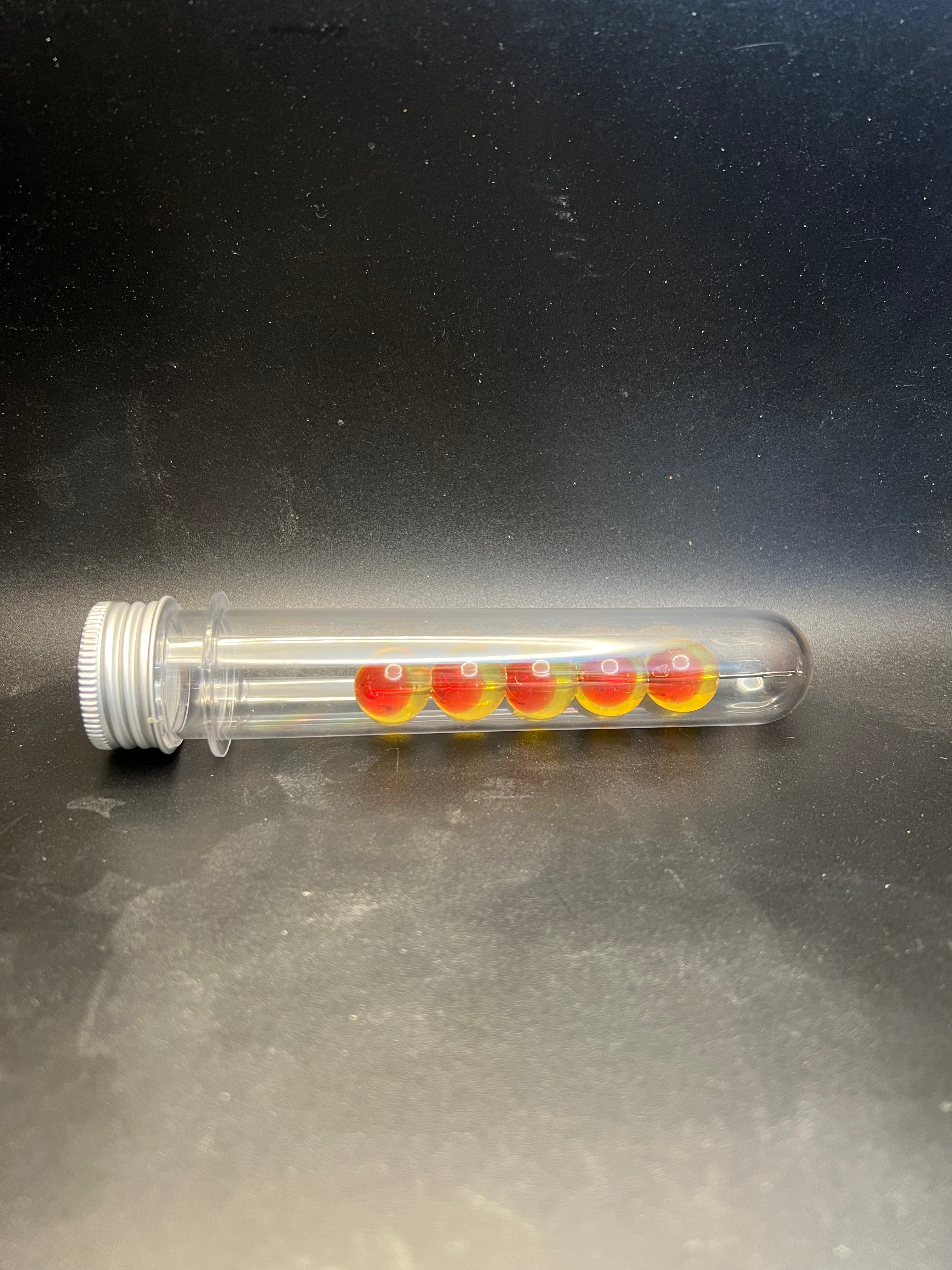 Embryo soft plastic beads in clear tube; translucent red-orange and yellow-green beads