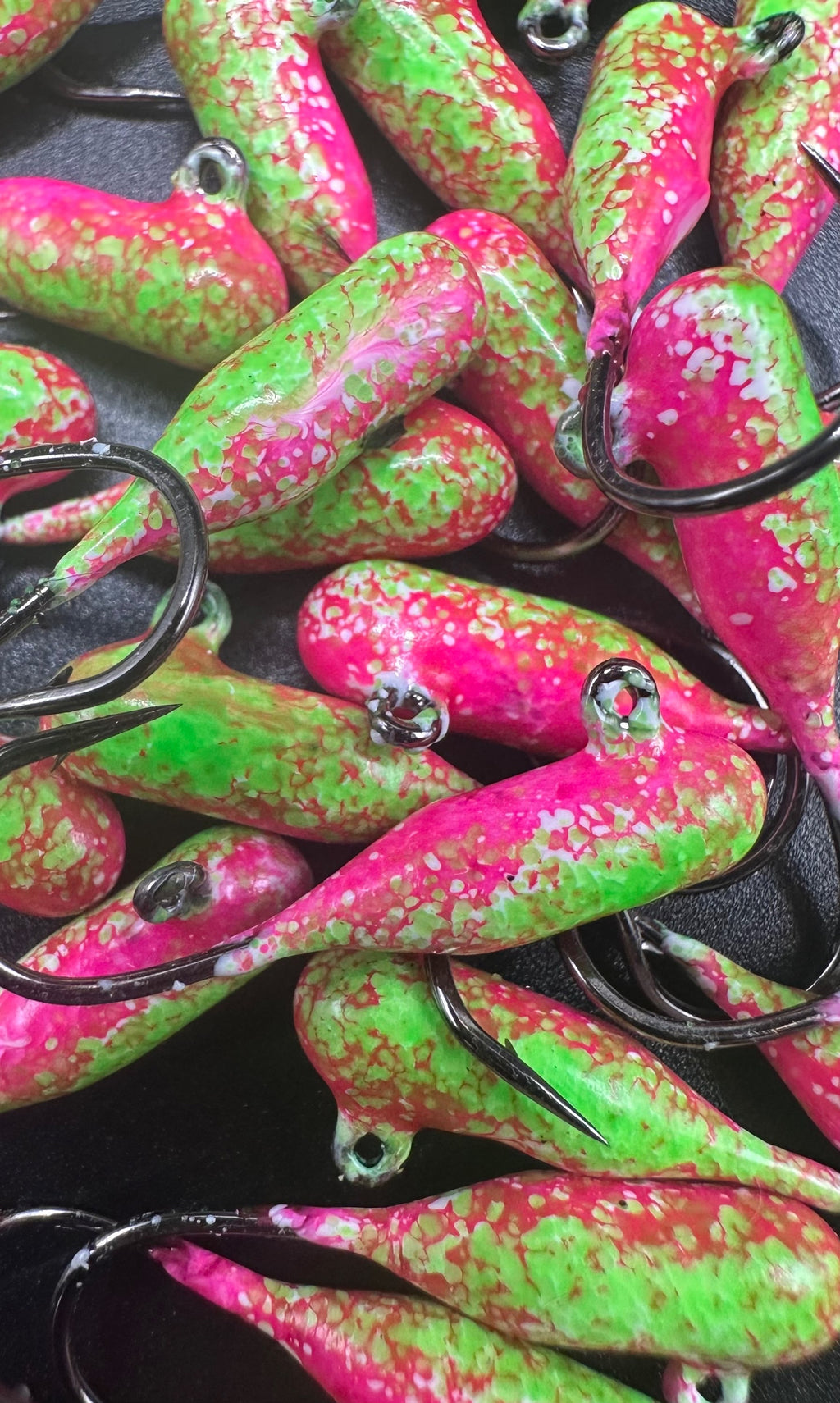 Pink and green speckled tube jigs with black hooks, rainbow sherbet style