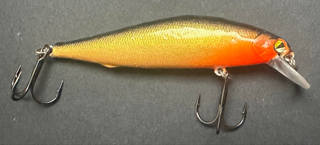 Gold Rush jerkbait, gold body with orange head and treble hooks