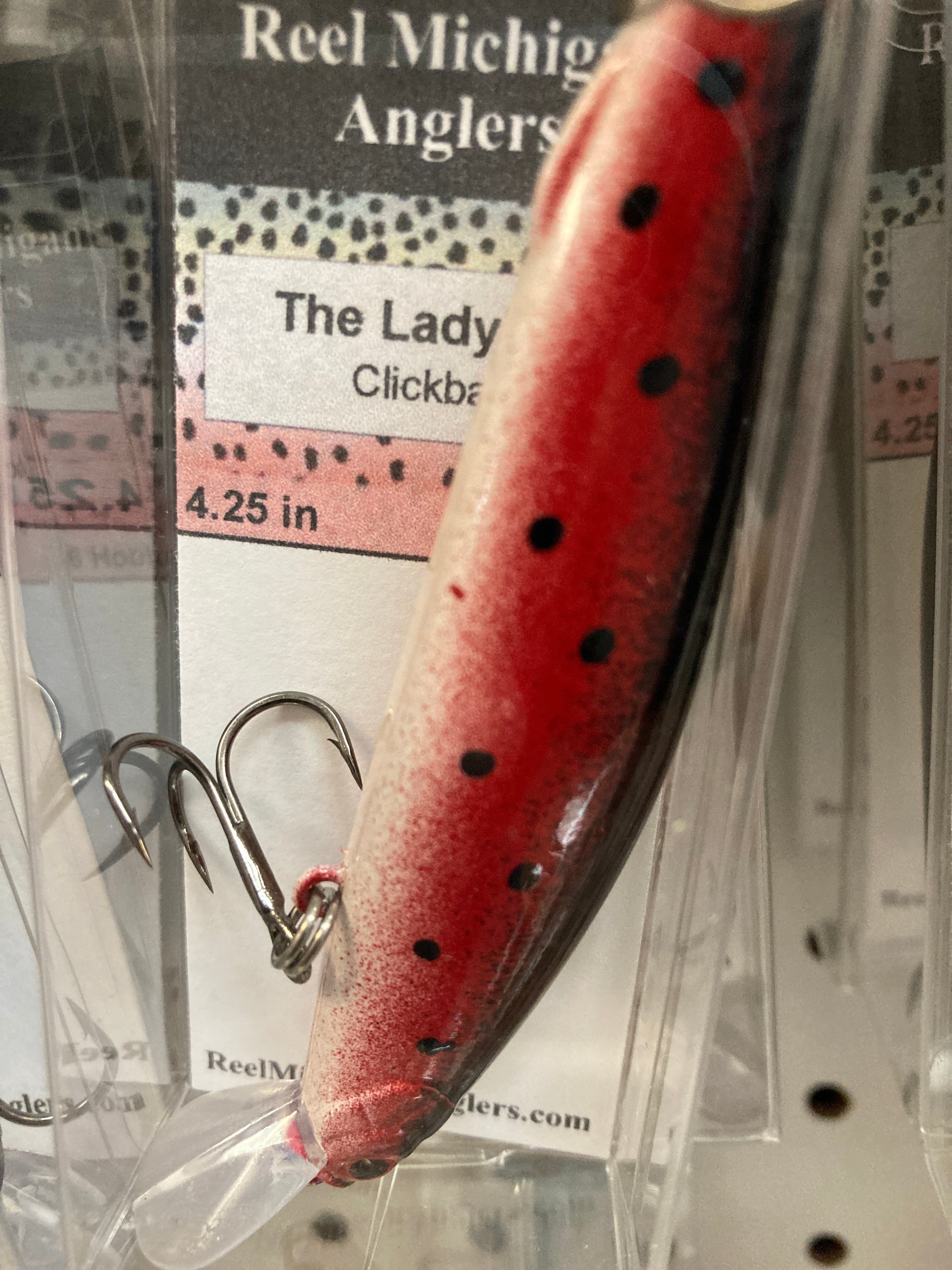 Red fishing lure with dark dot pattern, treble hooks, 4.25 in.
