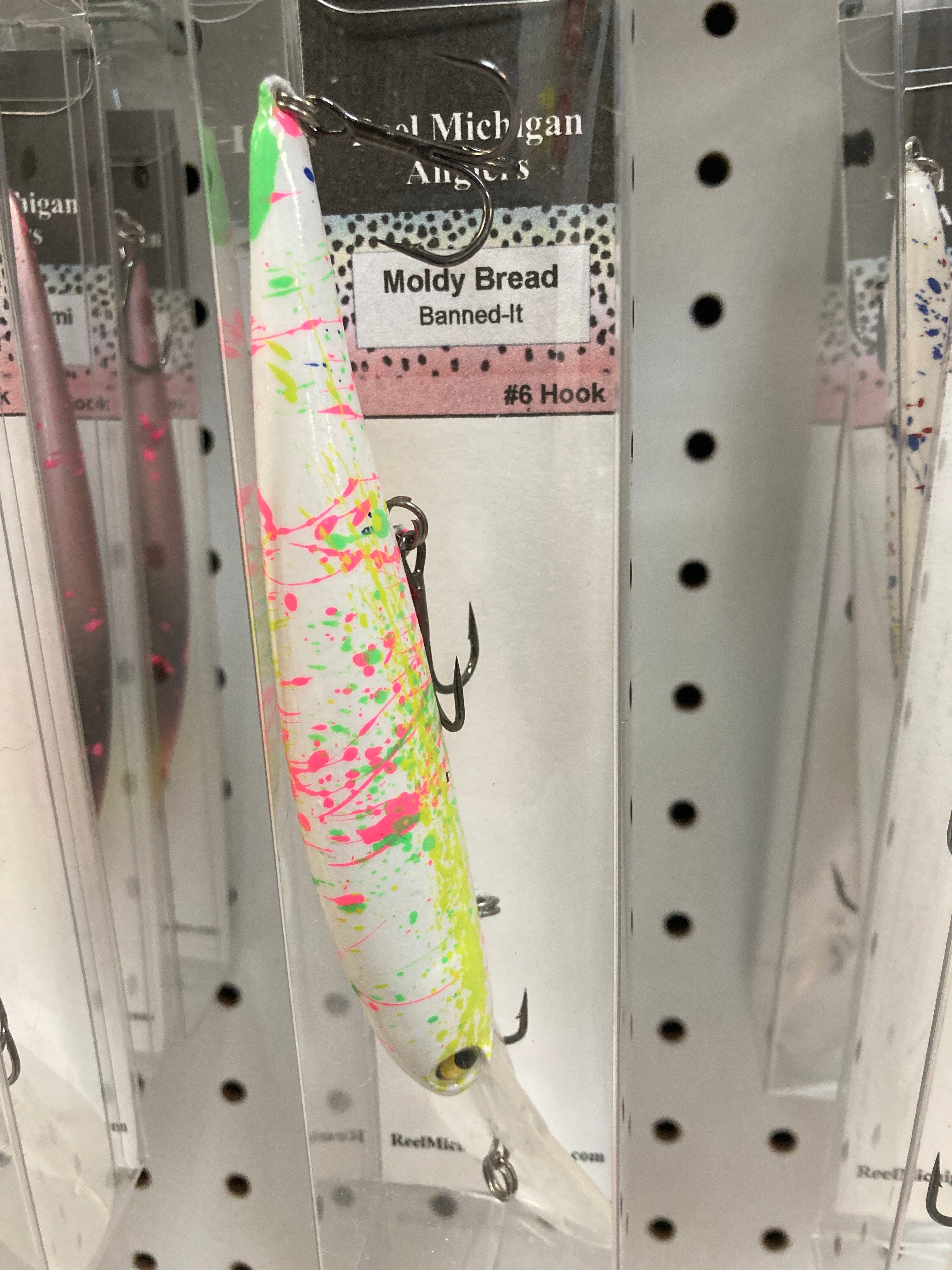 Fishing lure with cream body, green and pink splatter, and treble hook