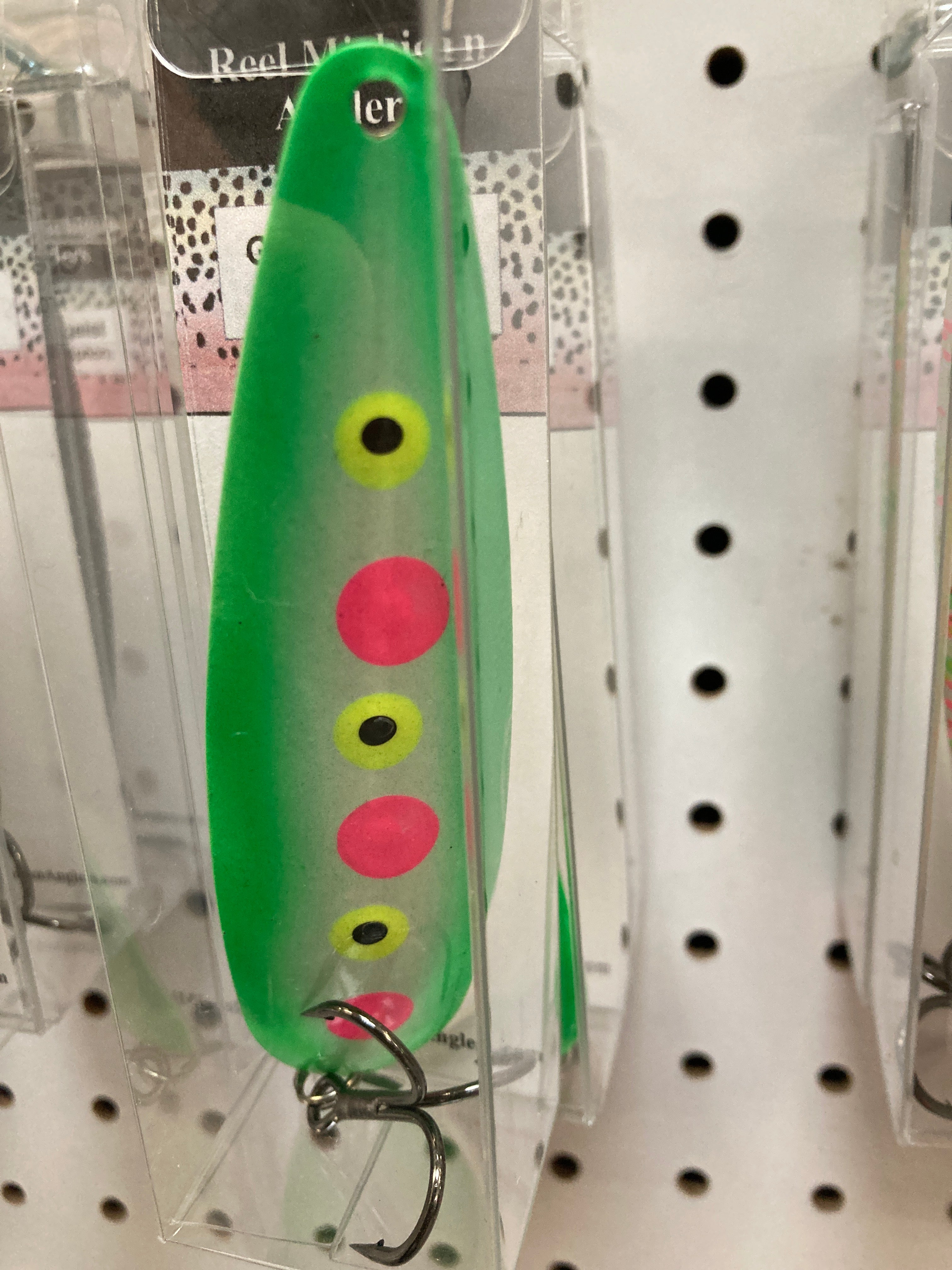 Bright green trolling spoon with yellow and pink/red dot spots, in blister pack