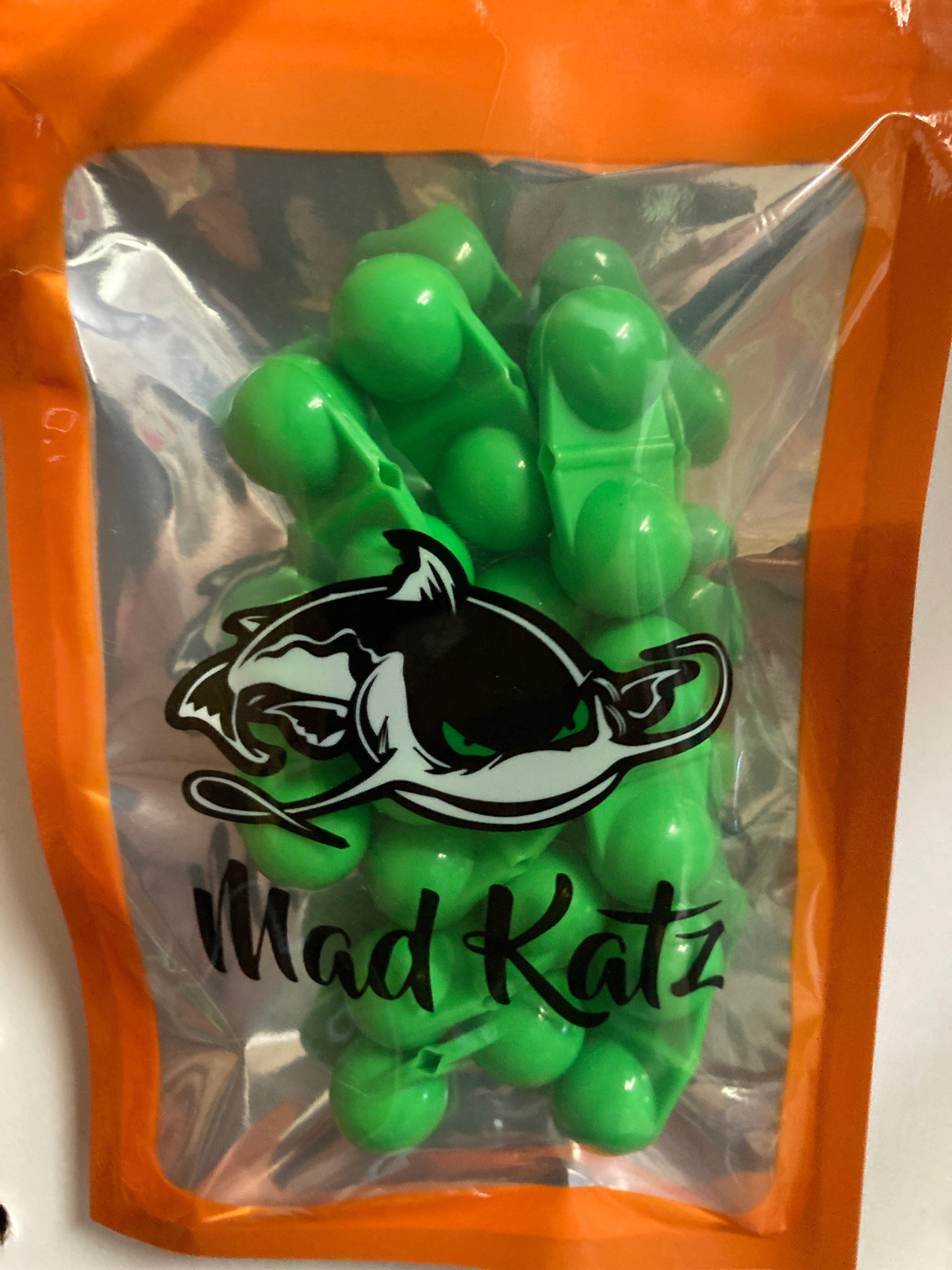 Green cat rattle toy with Mad Katz logo, orange pouch filled with rattle balls