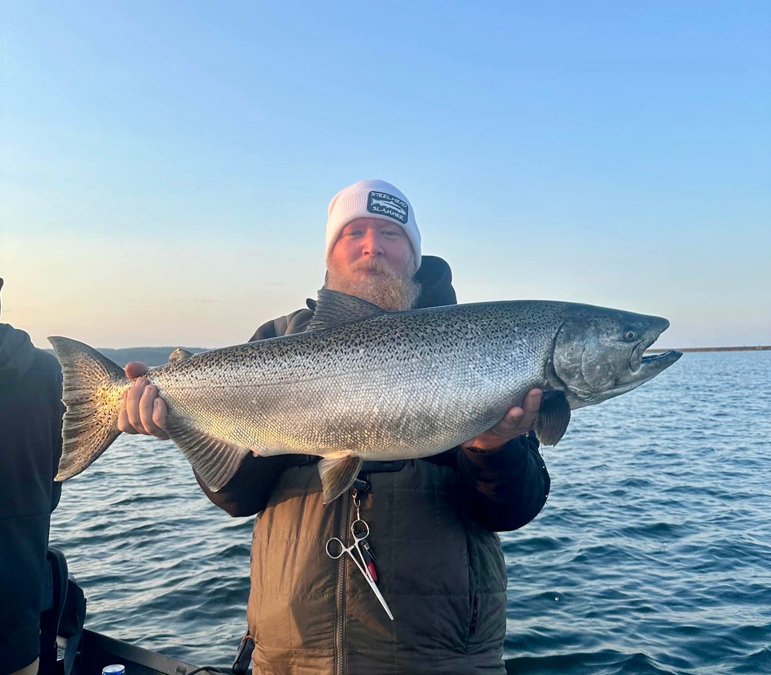 Caught striped bass held by an angler over the ocean