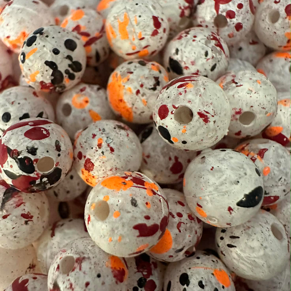 White plastic fishing beads with orange and red speckle spots and central hole