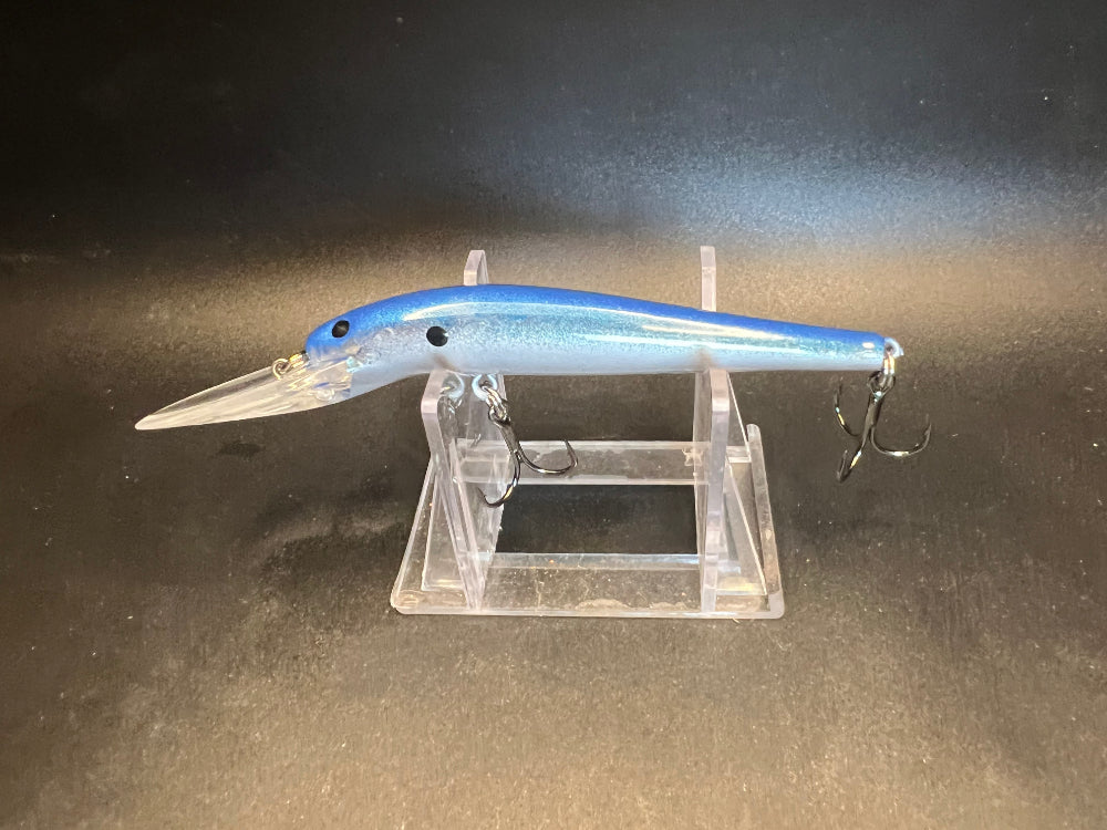 Blue Lagoon lightningstick fishing lure in blue, with 3 hook set on clear display stand