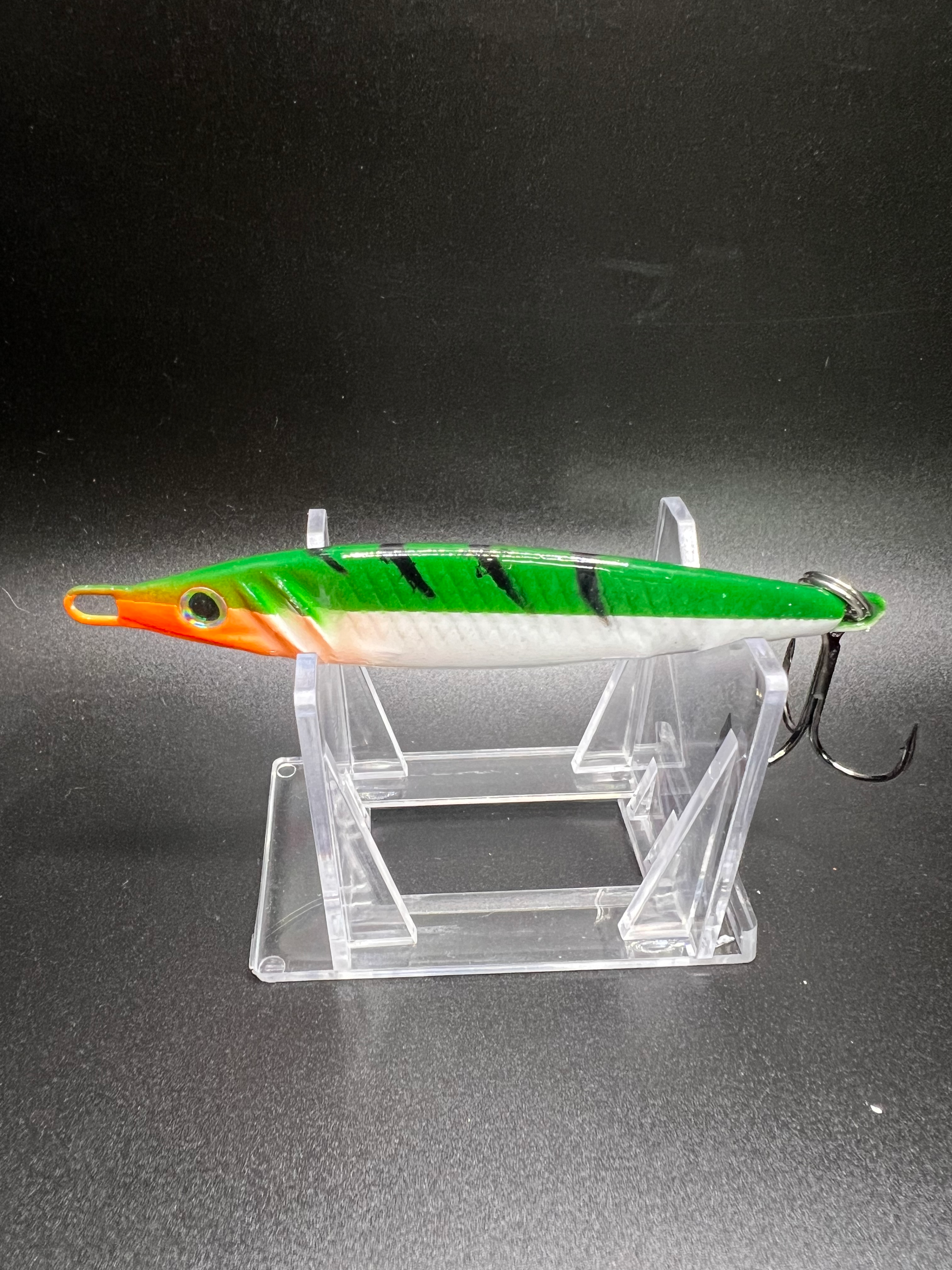 Green-and-orange 2 oz jigging spoon lure with black stripes and treble hook