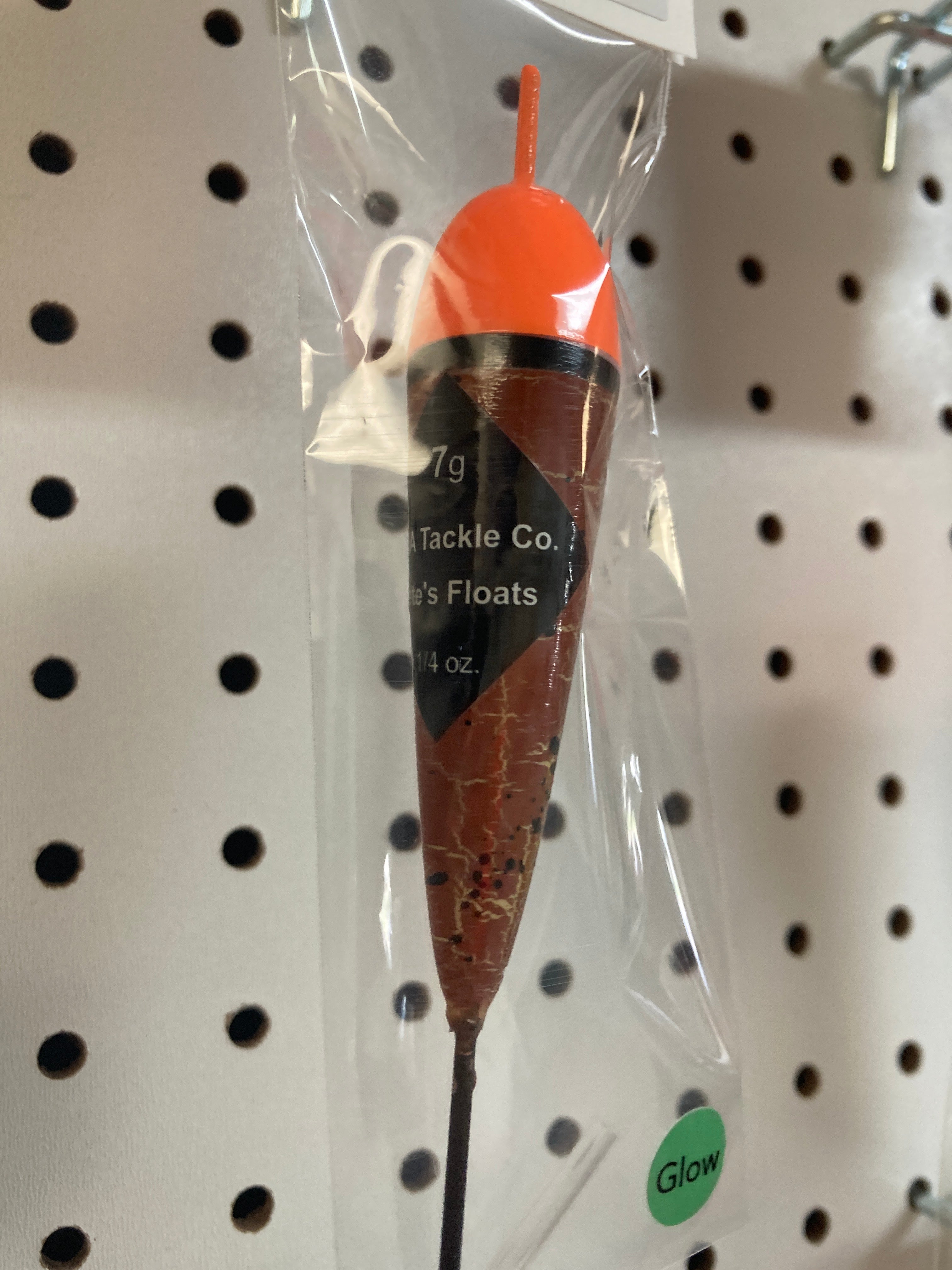 Fishing float in clear bag, orange cap with black band, brown body on stick