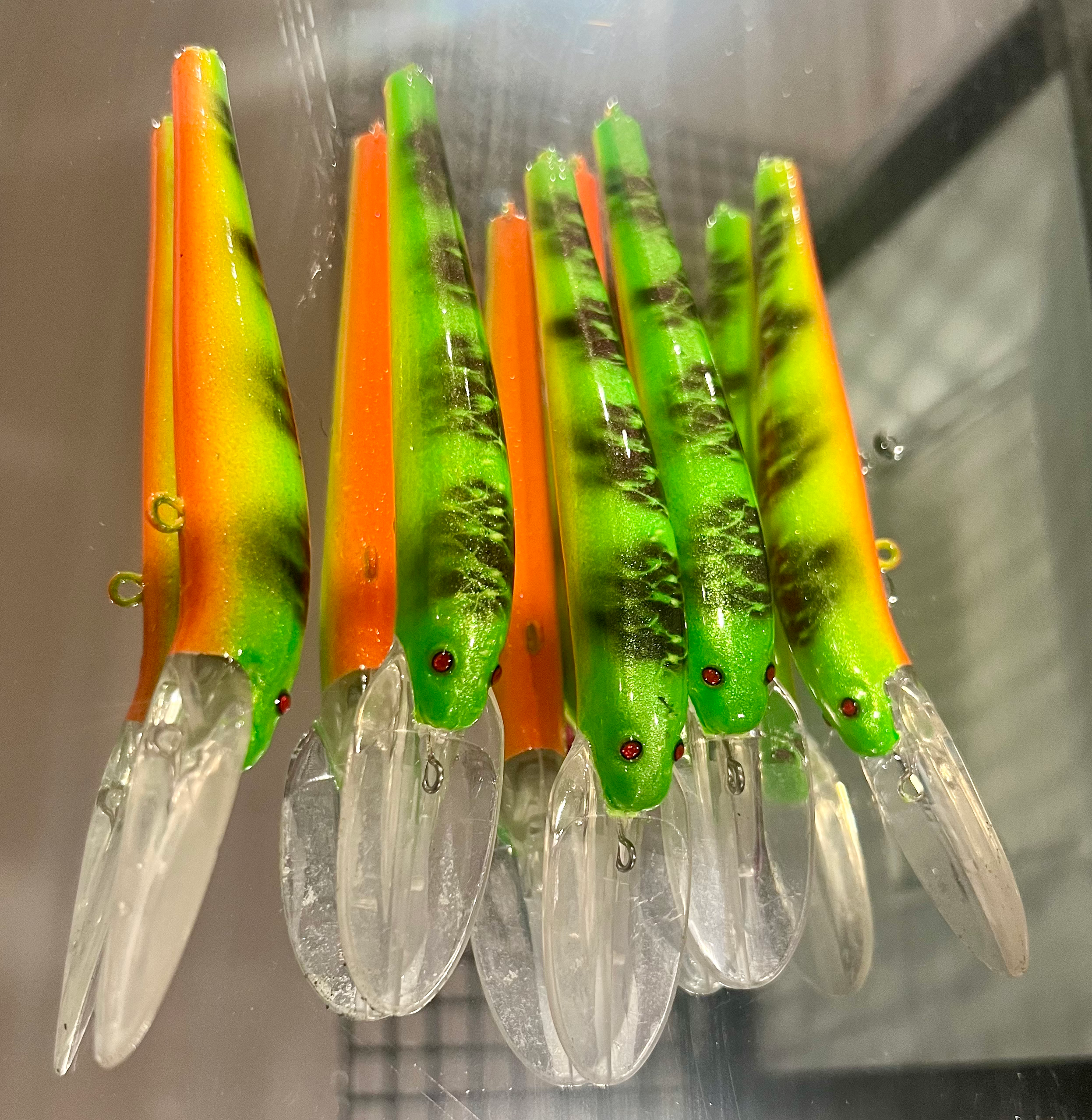 Set of neon orange-and-green UV Glow Lightningstick lures with clear fins and hooks