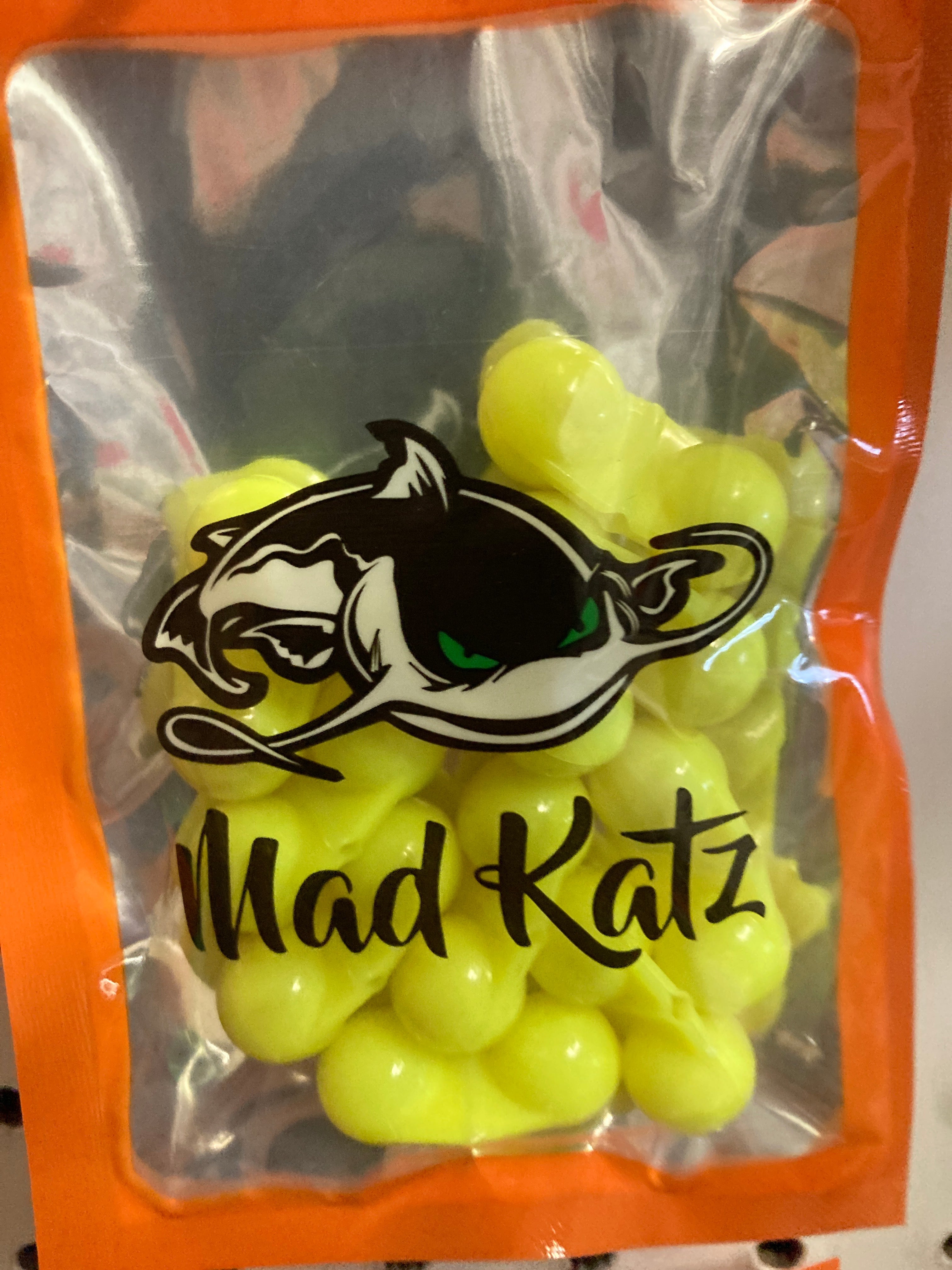 Yellow cat rattle toy with Mad Katz logo, orange pouch filled with rattle balls