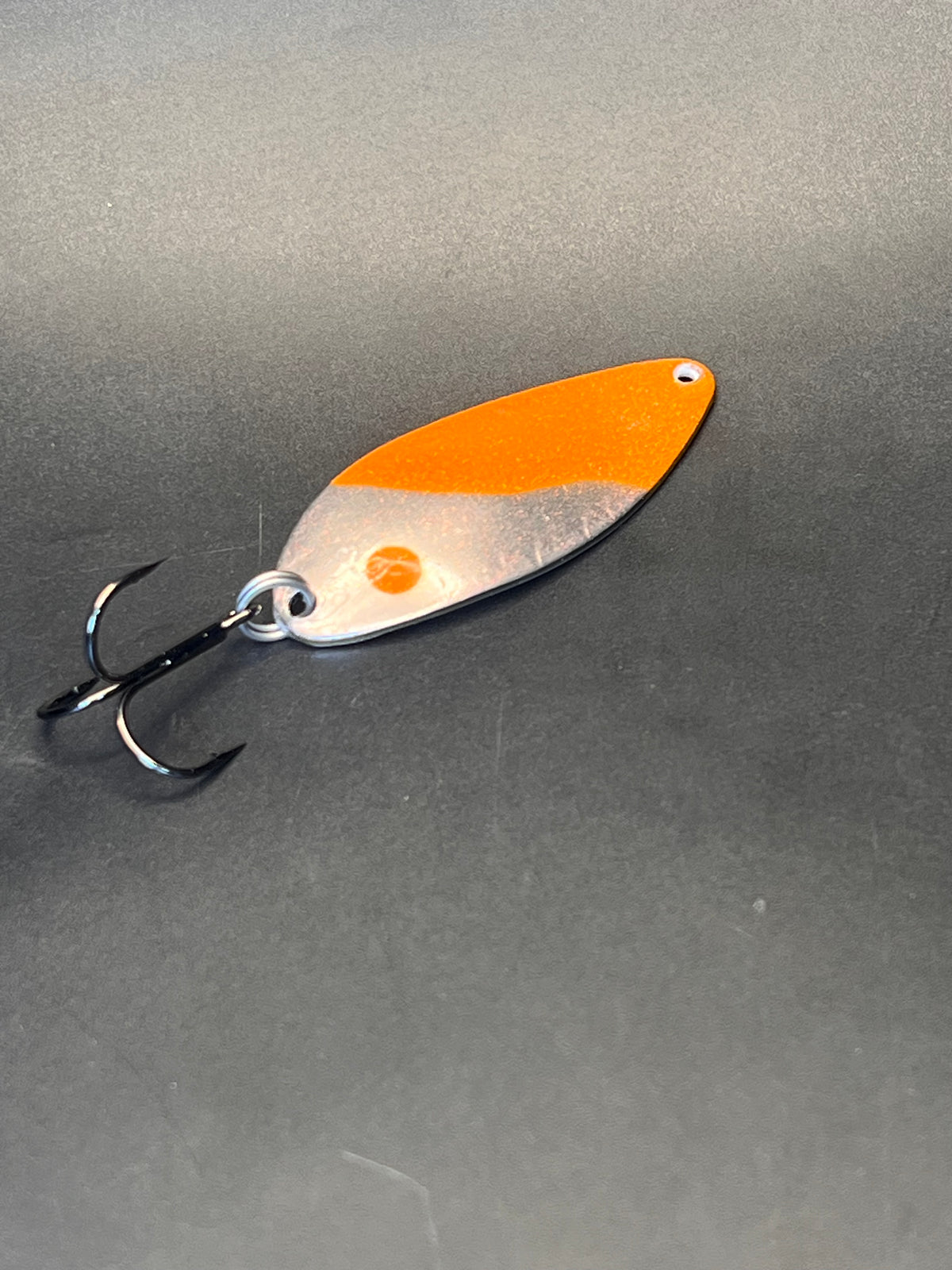 Casting spoon with orange top and silver body, double treble hooks