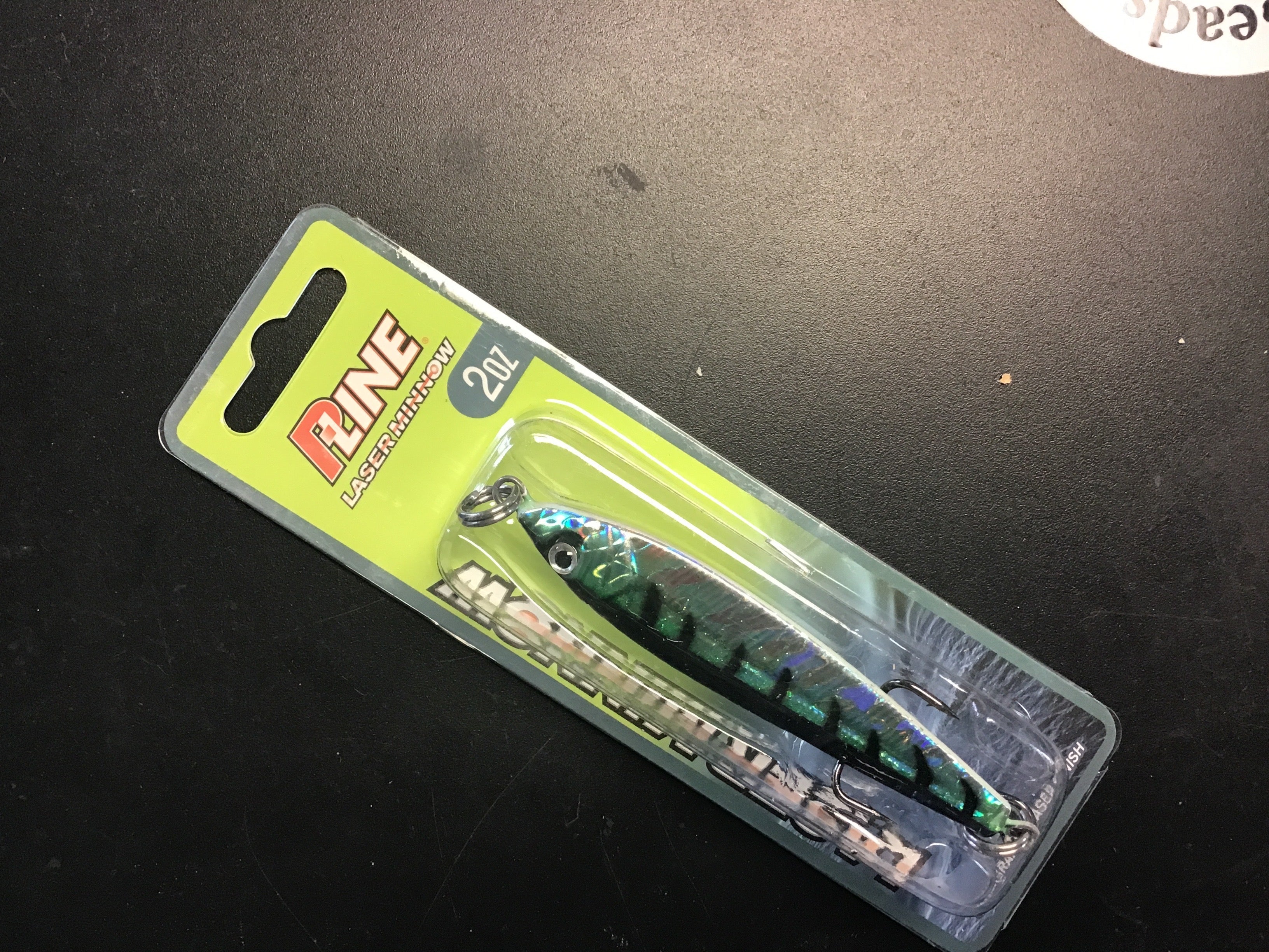 Holographic green and blue jigging spoon with black top and chrome hook