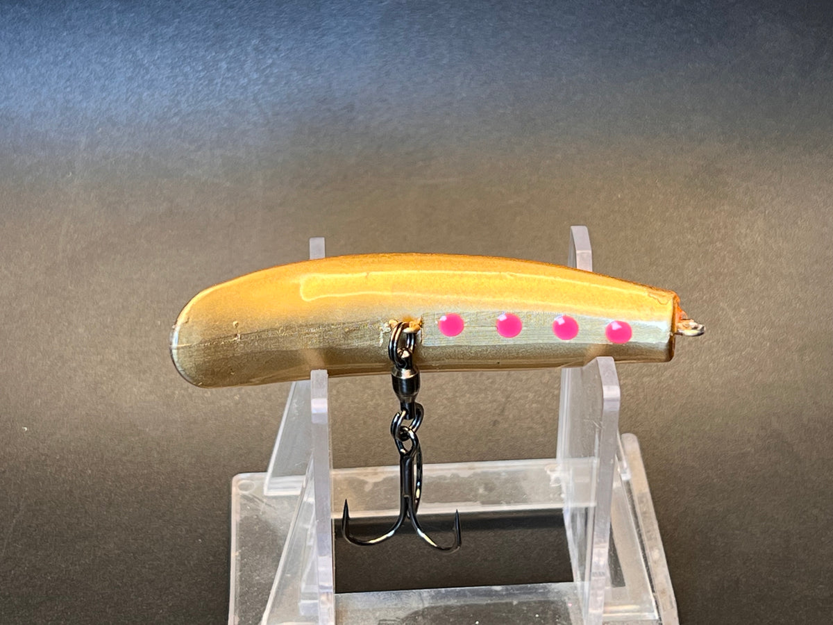 Gold crankbait fishing lure with pink dot detail and treble hook on stand