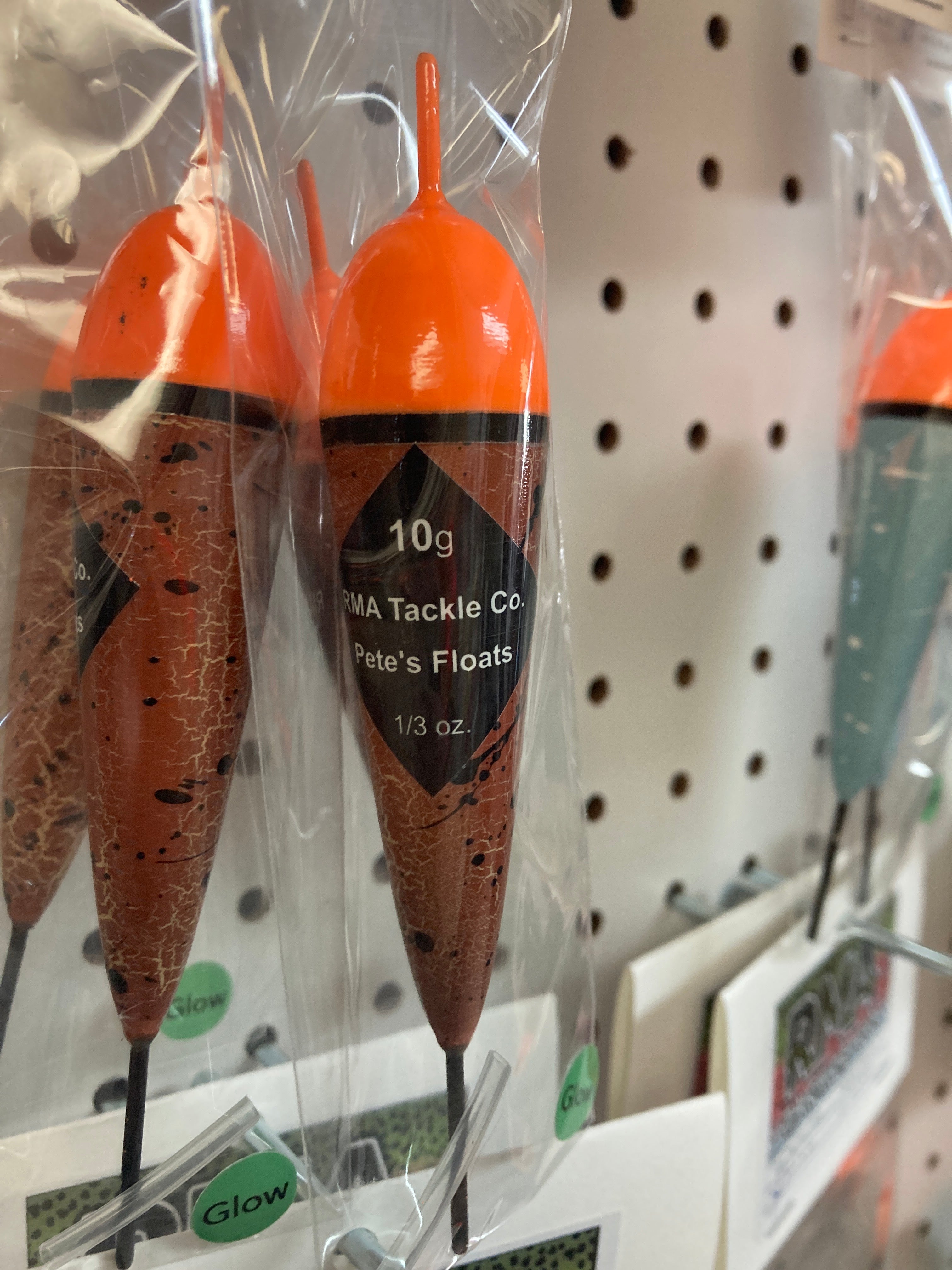 Fishing float in clear bag, orange cap with black band, brown speckled body