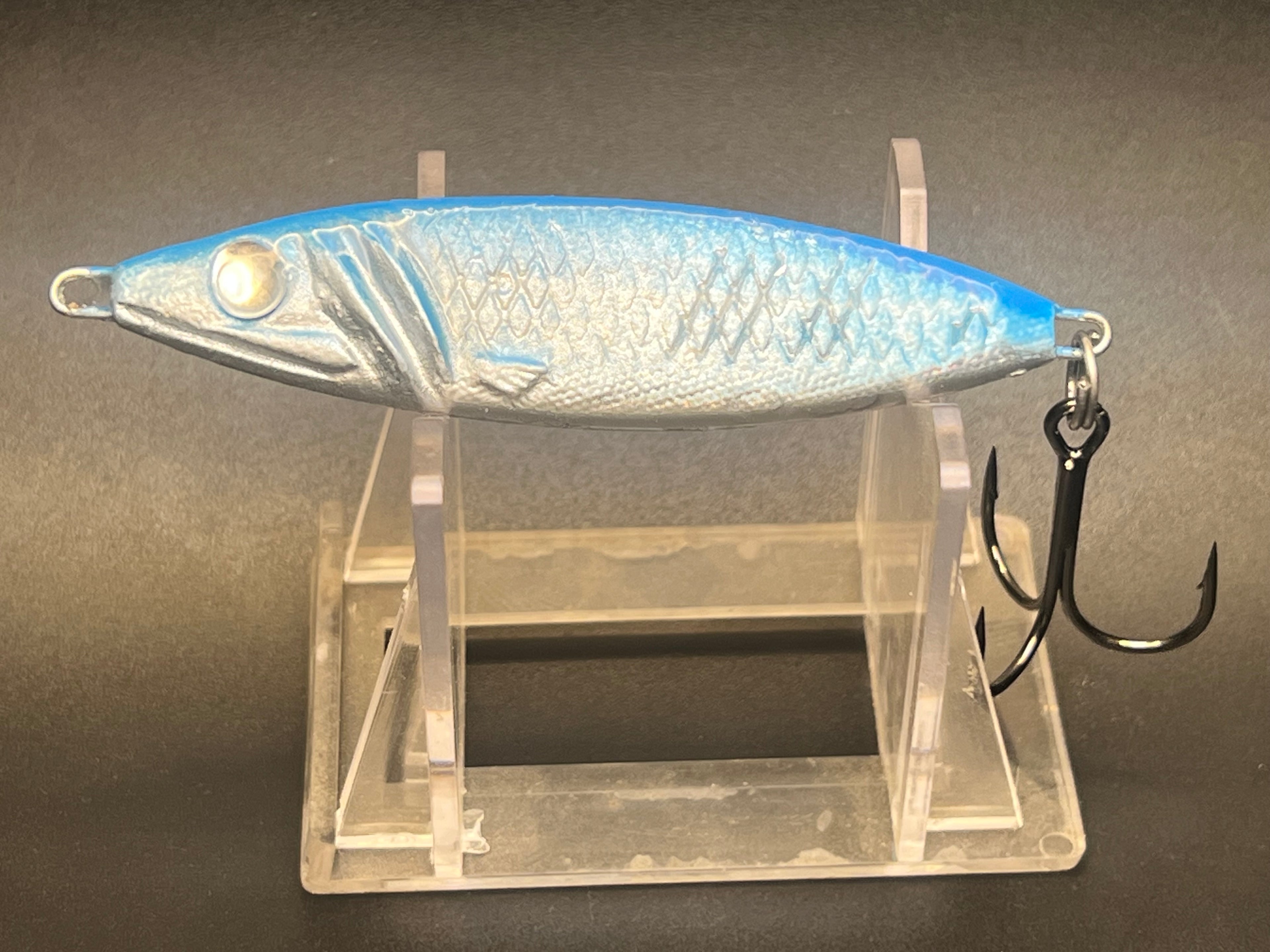 Metallic white and blue UV jigging spoon with eyelet and single treble hook