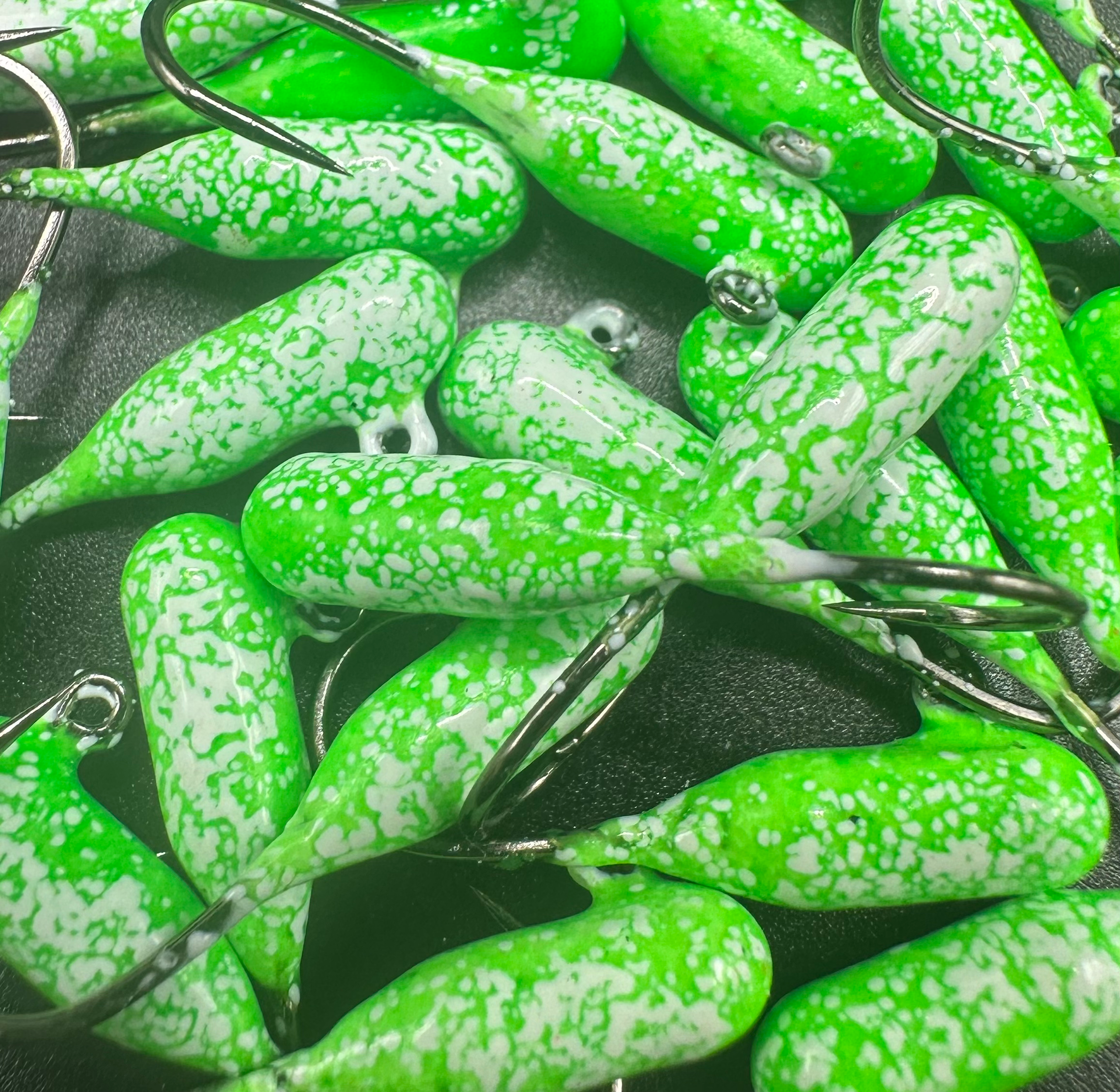 Green-and-white speckled tube jigs with barbed hooks and split rings