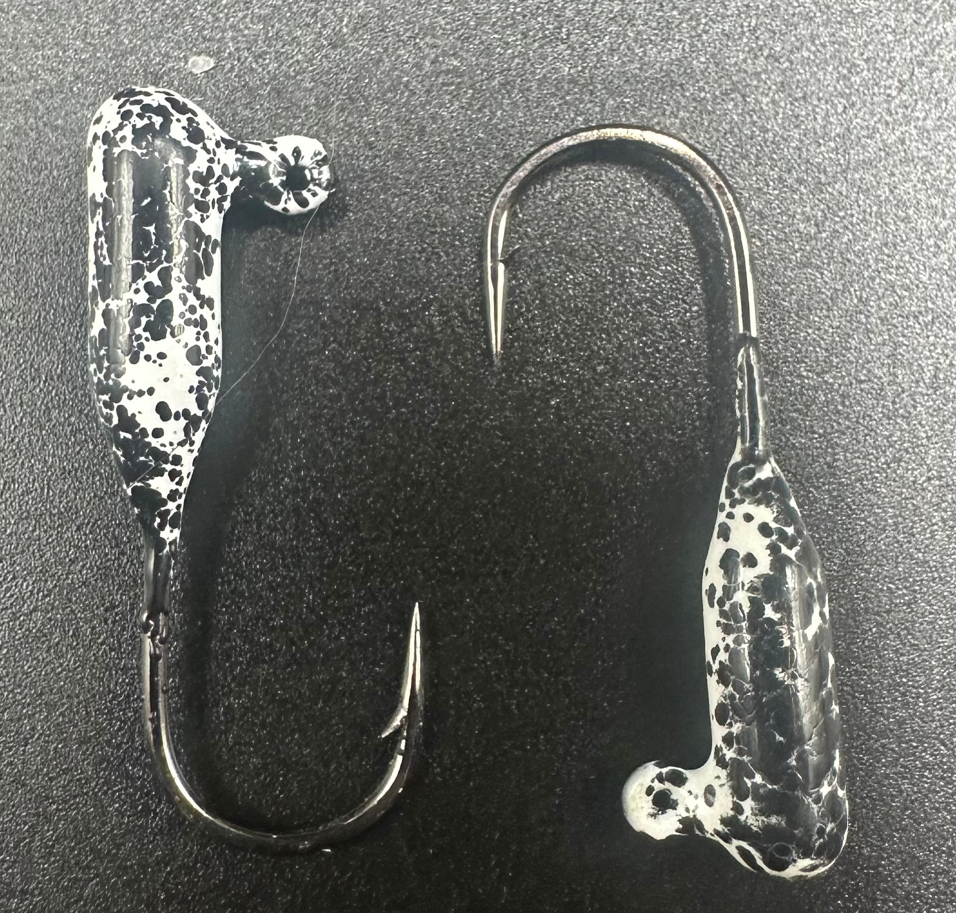 Speckled tube jig with curved hook and molded head, black-and-white