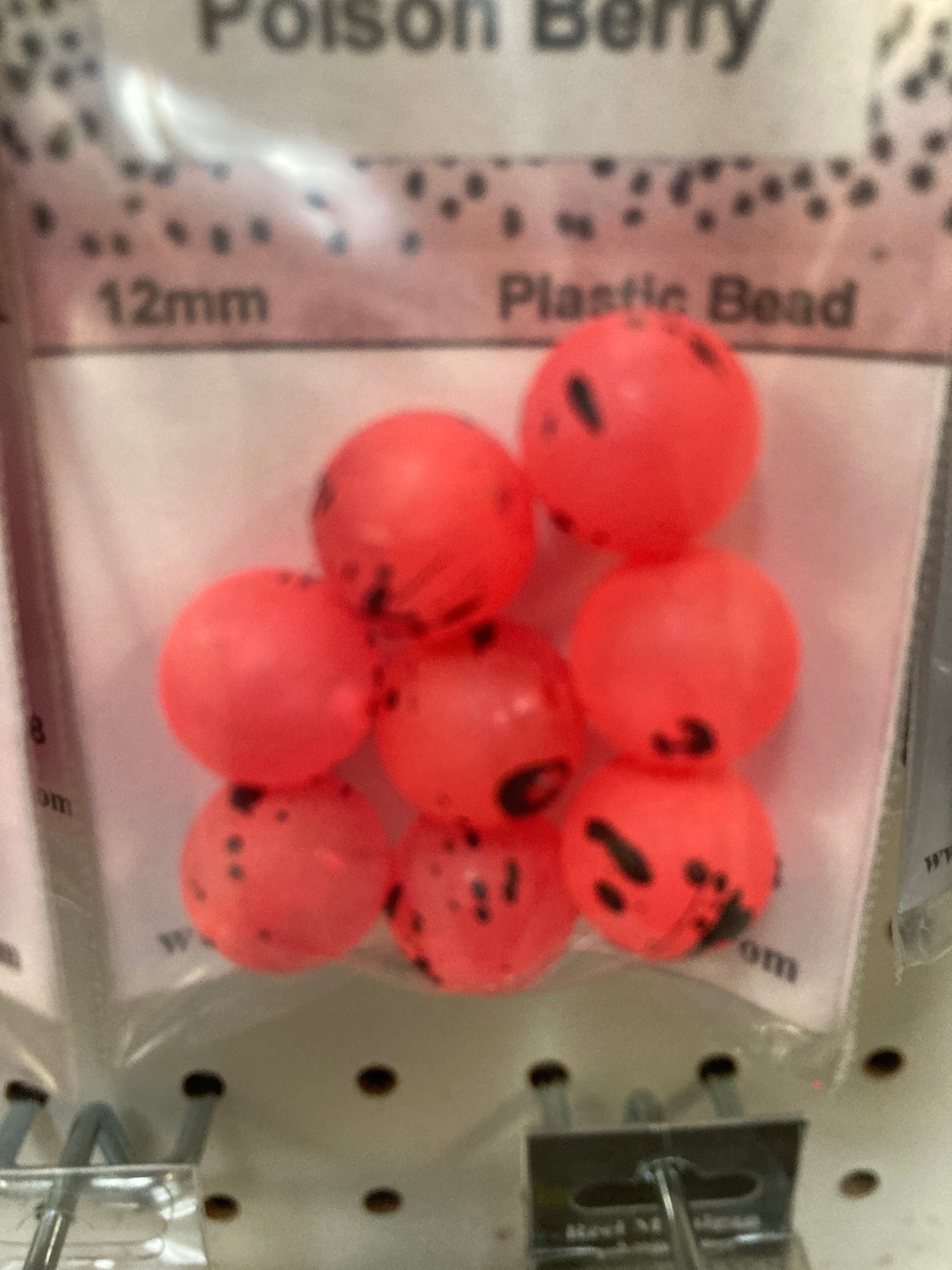 Red plastic beads in bag, round beads with black speckles, 12mm label visible