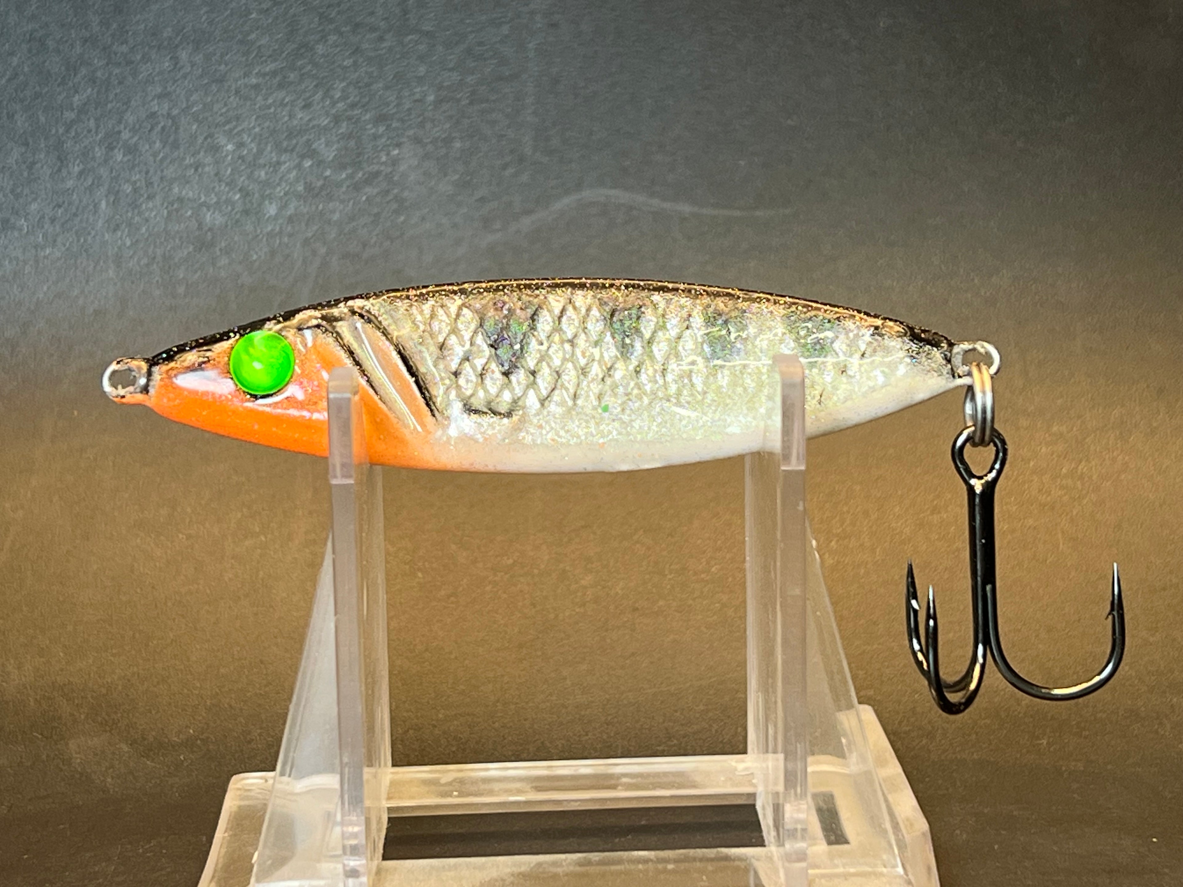 Salmon jigging spoon, metallic silver with orange head, green eye, treble hook