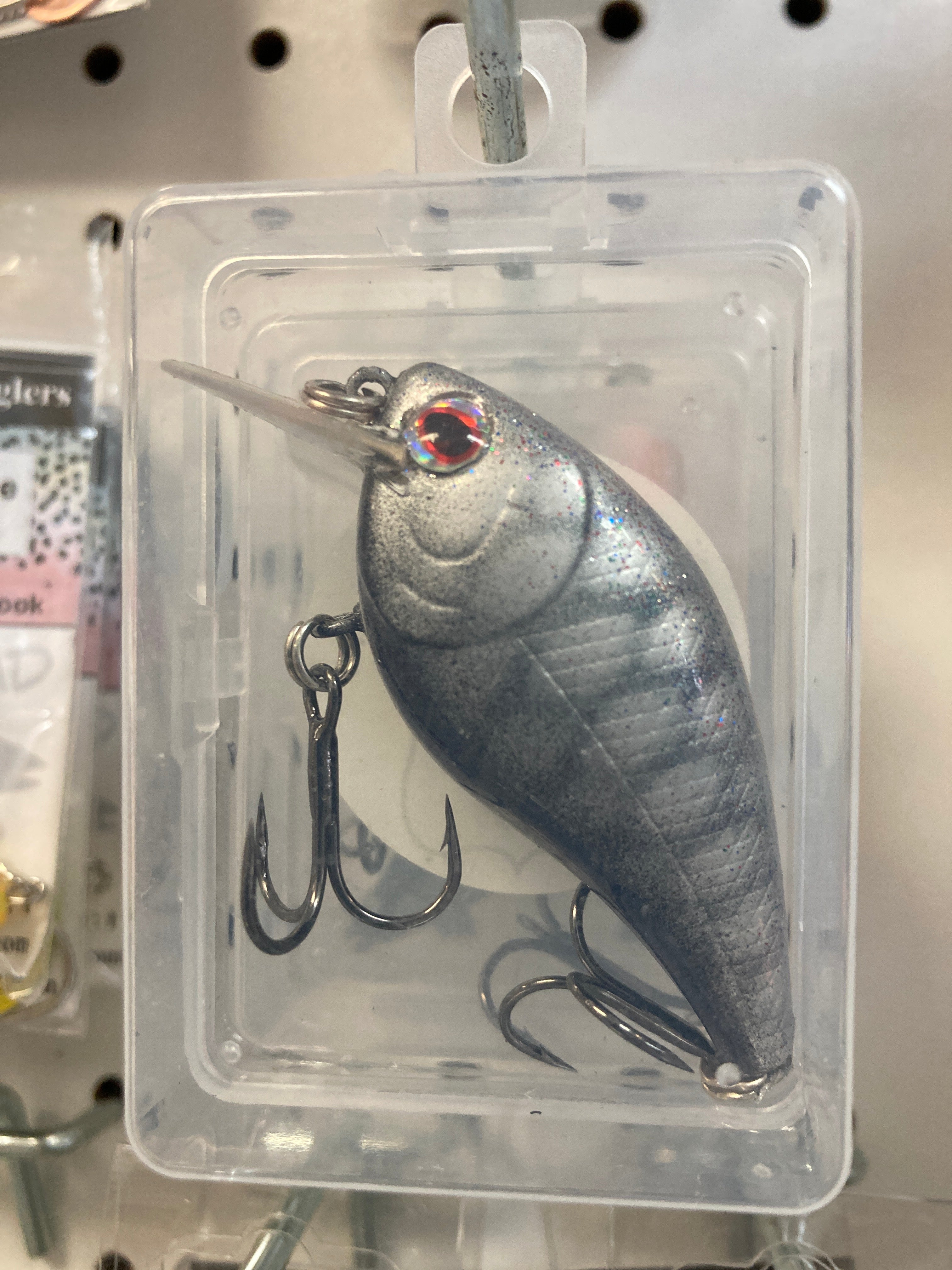Silver fishing lure with red eye, square bill, metal body, treble hooks