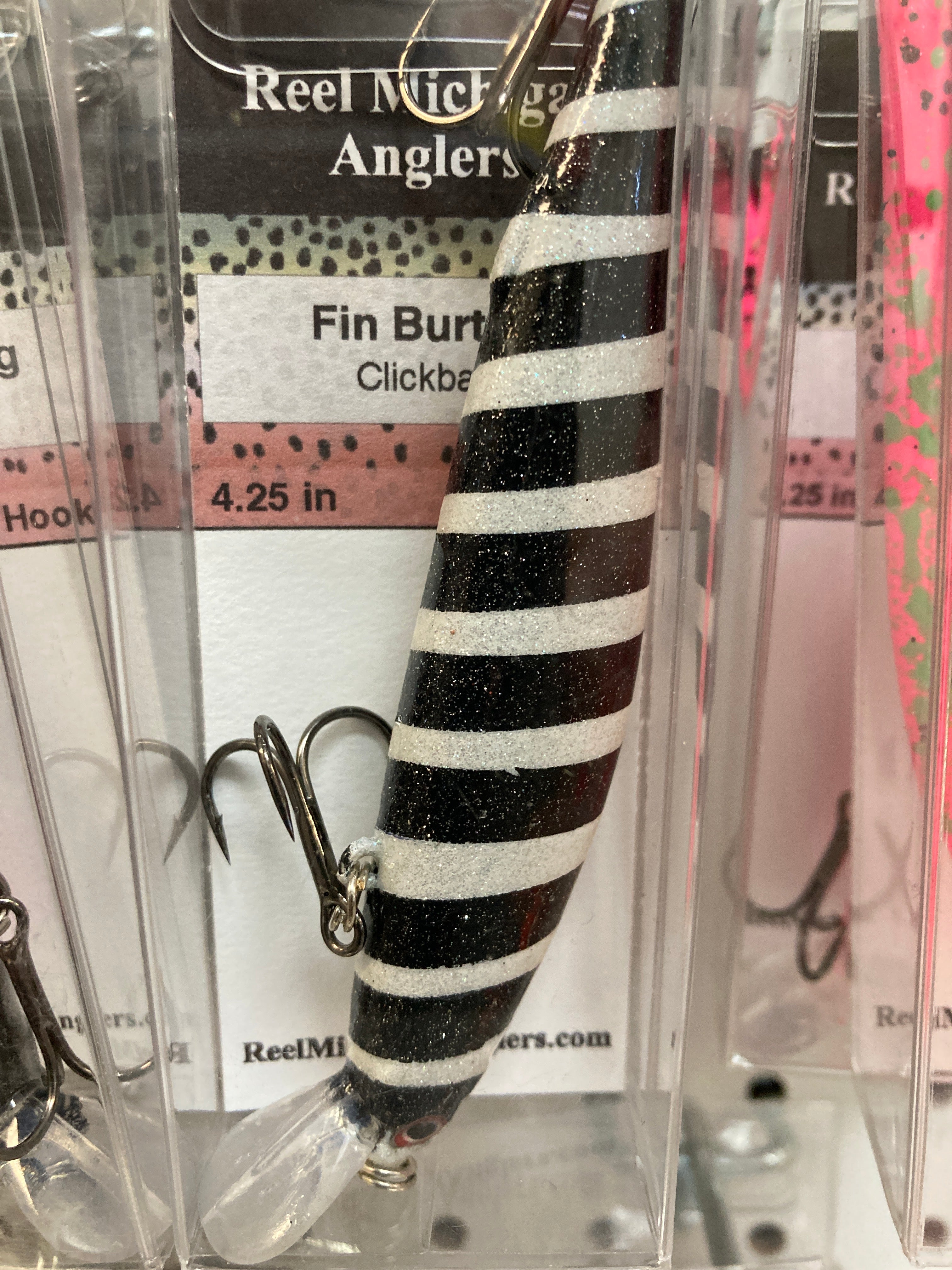 White fishing lure with black horizontal stripes, treble hooks, 4.25 in.