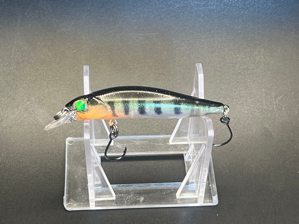 Small silver-blue jerkbait with orange belly, green eye, and two treble hooks