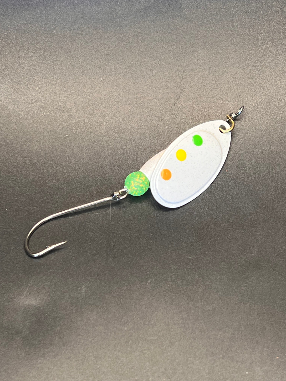 Inline spinner fishing lure with white oval blade, multicolor dots, and green beads