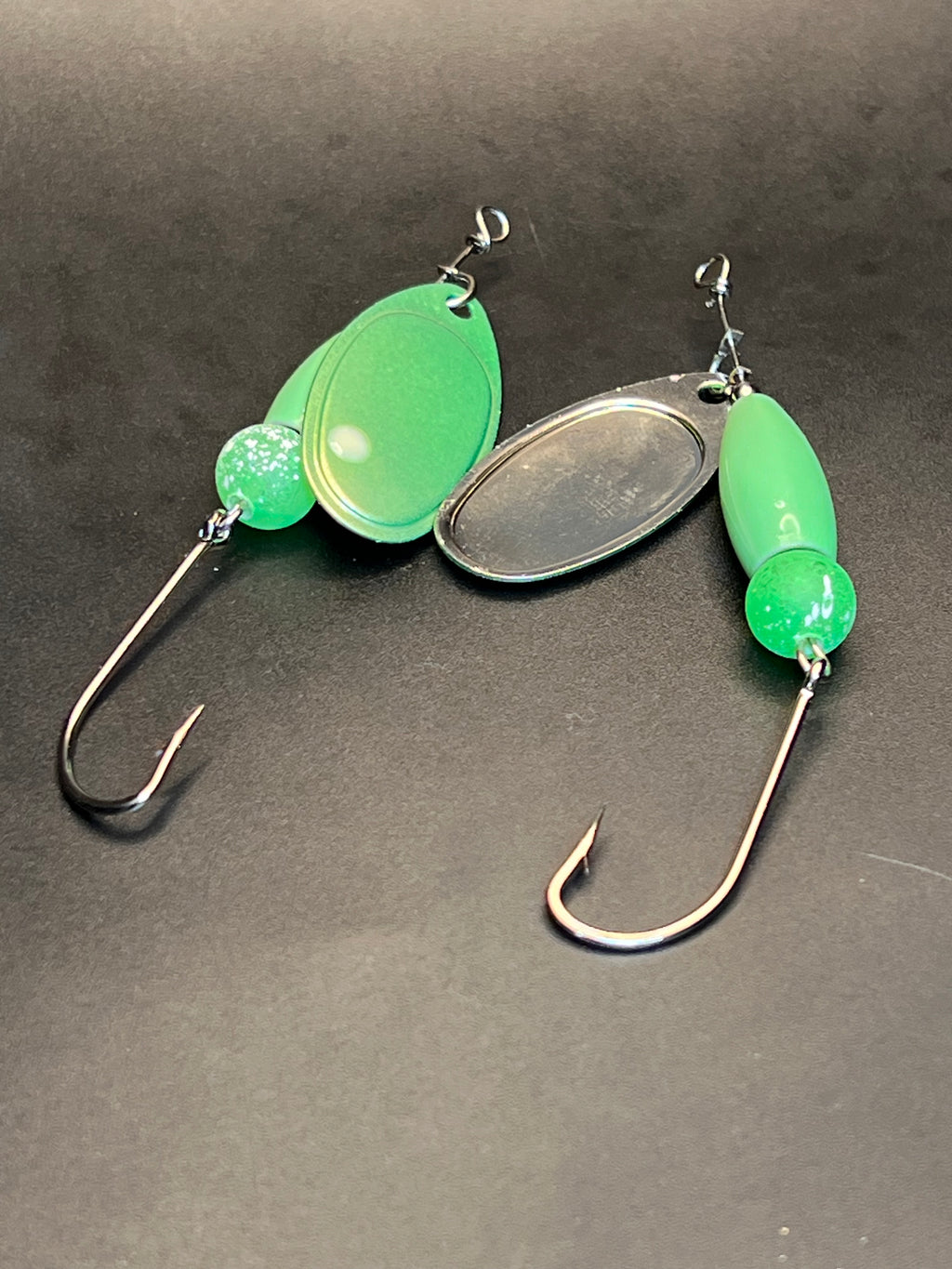 Set of green inline spinner lures with oval blades and long treble hooks