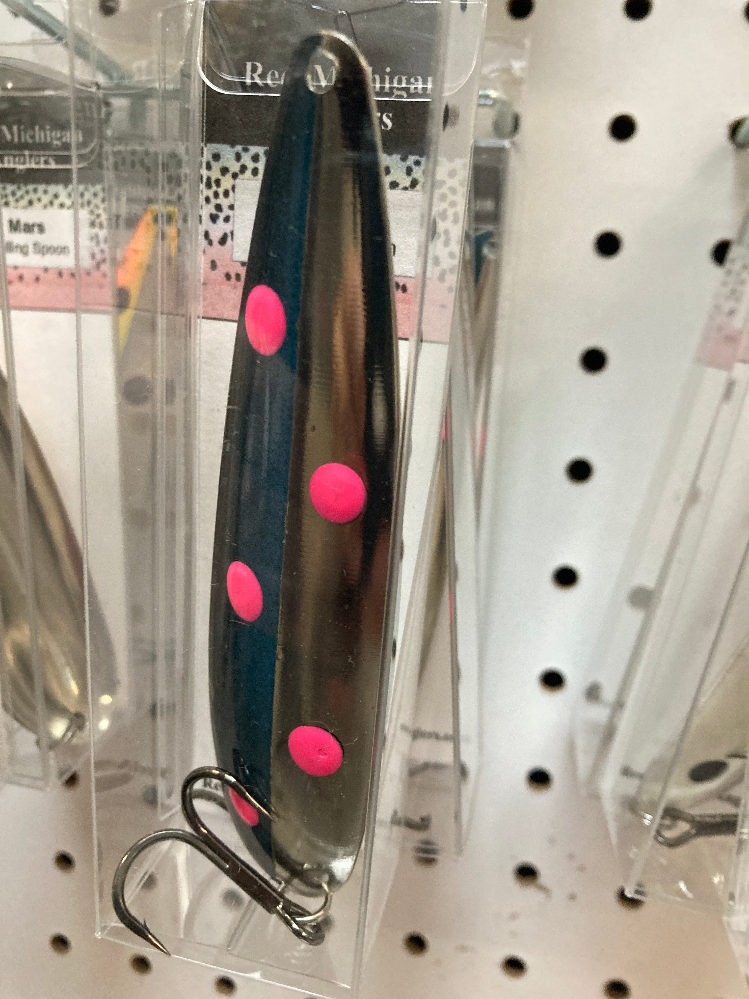 Metal trolling spoon lure with teal body, pink dot accents, and wire hook.