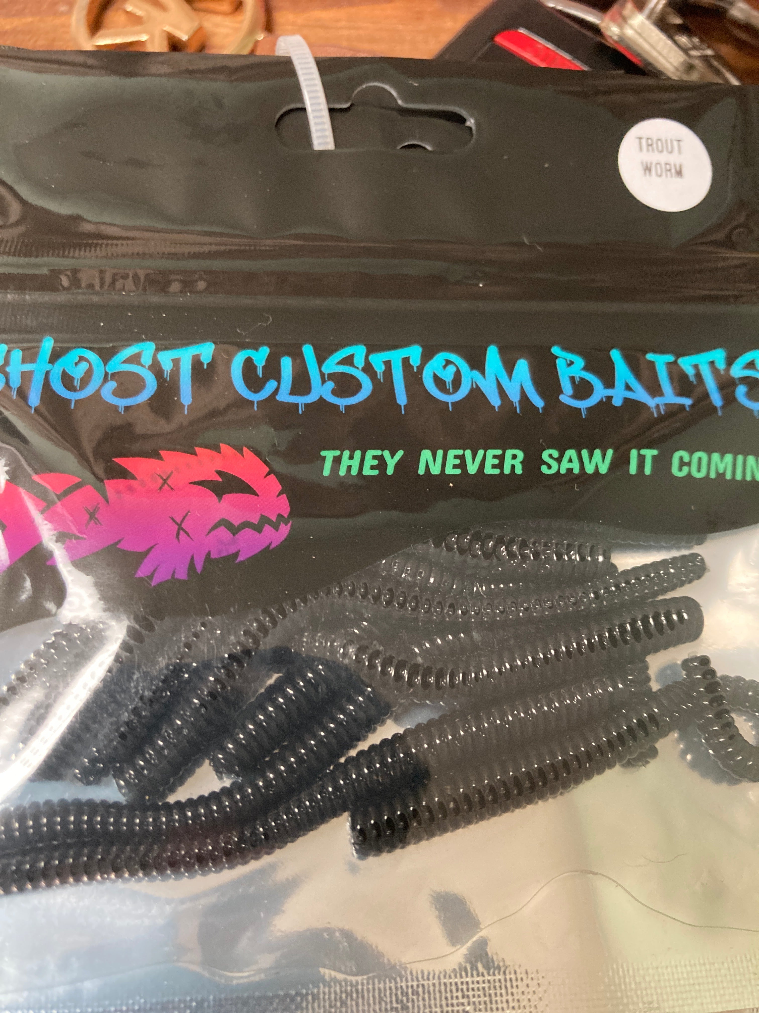 Dark gray custom worm bait with segmented ridges, packed in clear bag
