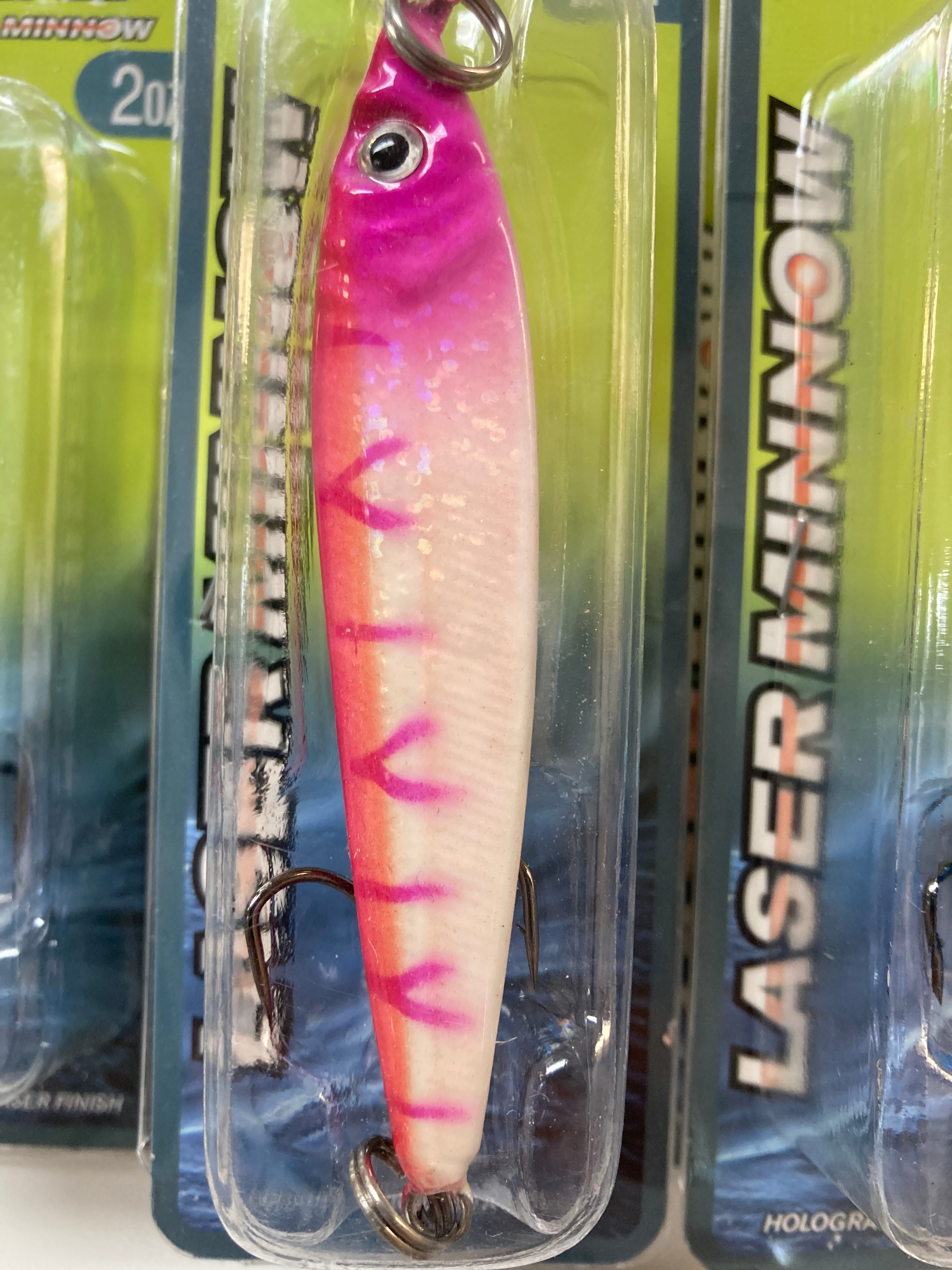 Pink and cream jigging spoon with red streak pattern, chrome hook and split ring