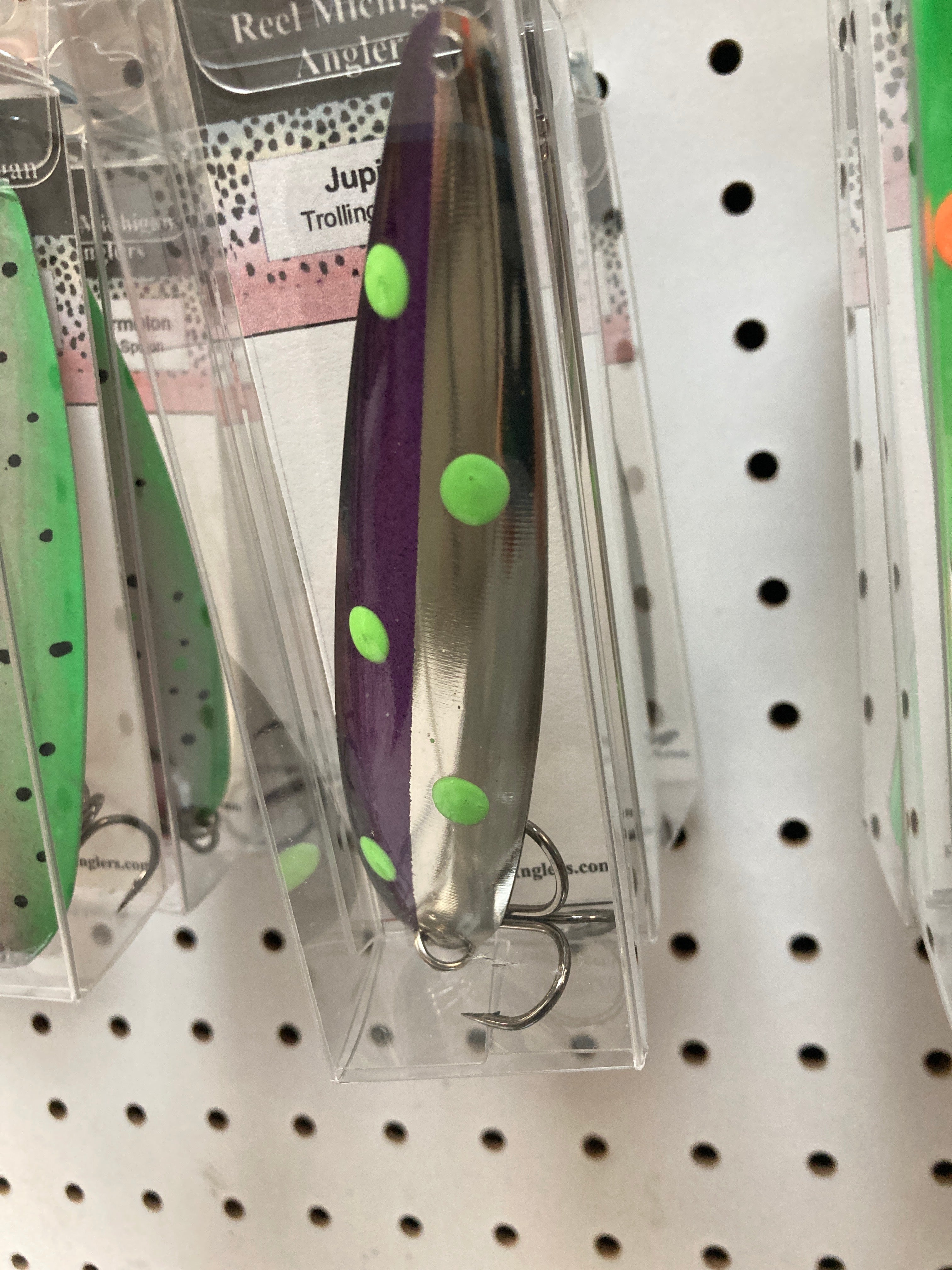 Purple trolling spoon with bright green spots, in retail blister pack