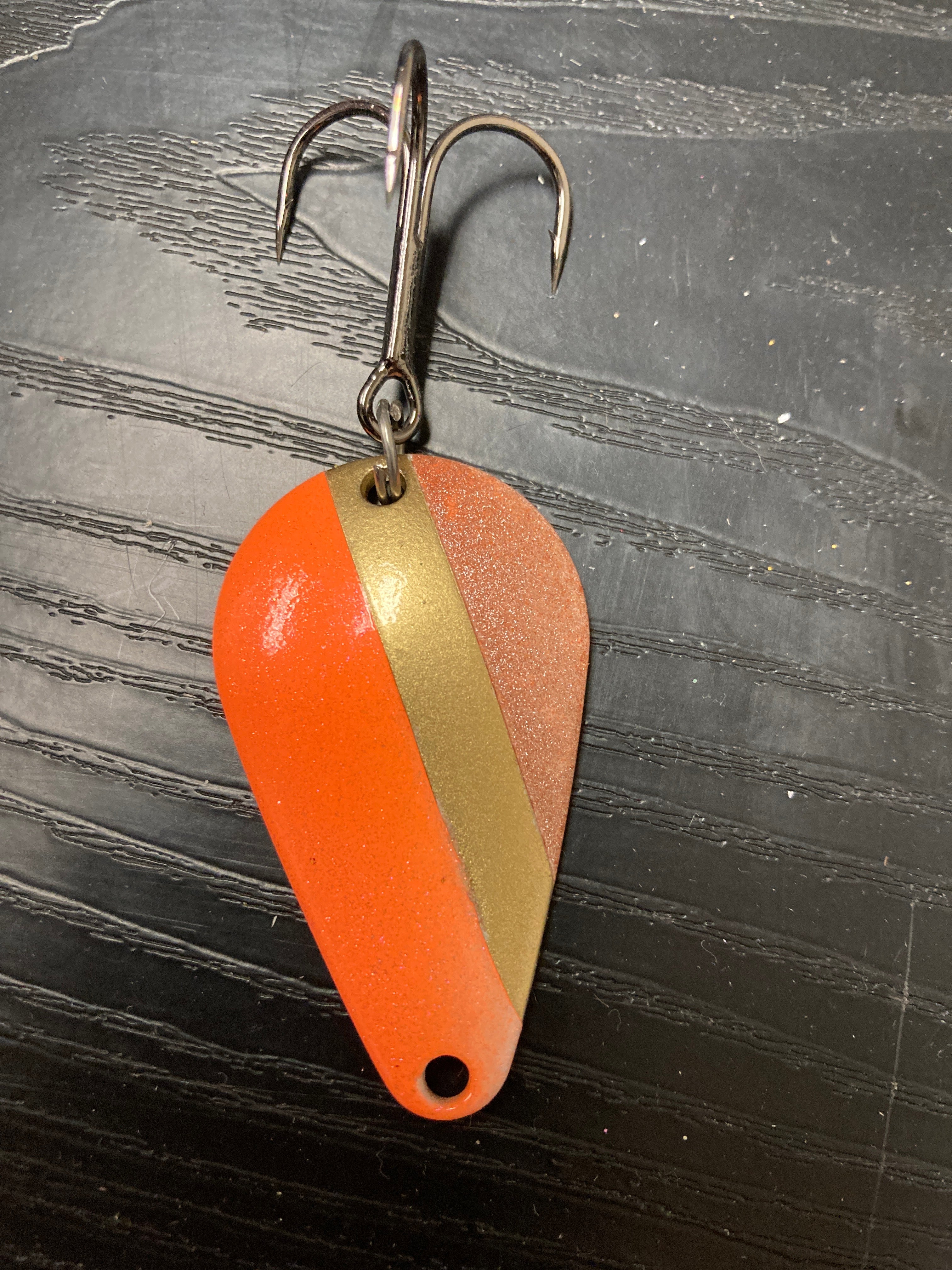 RMA casting spoon with orange and gold striped body and treble hooks