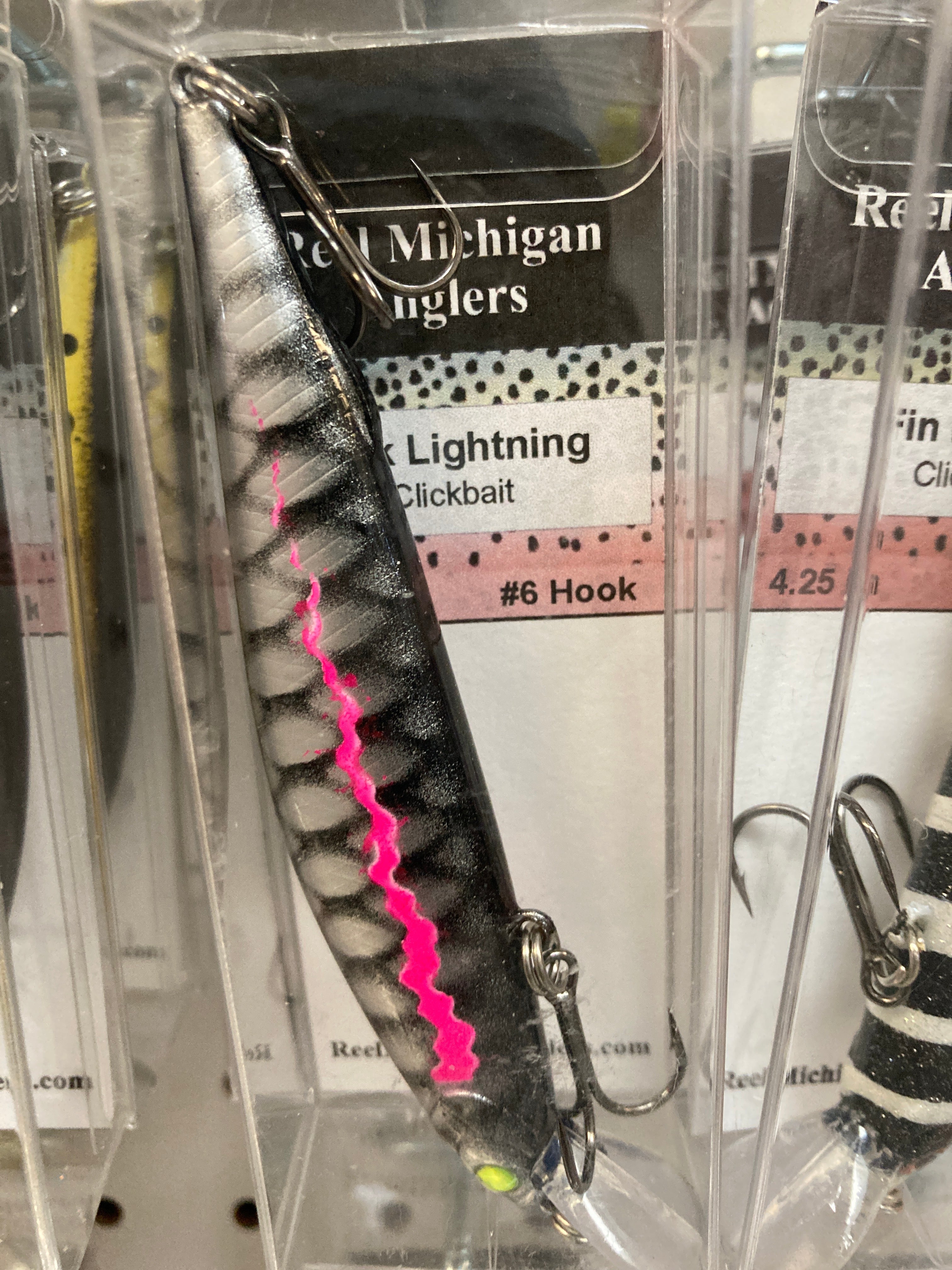 Black fishing lure with pink lightning stripe, treble hooks, 4.25 in.