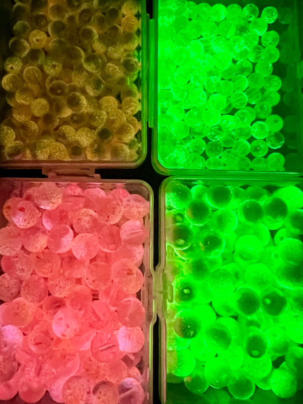 Glass fishing beads in bins: neon green and pink round beads with holes
