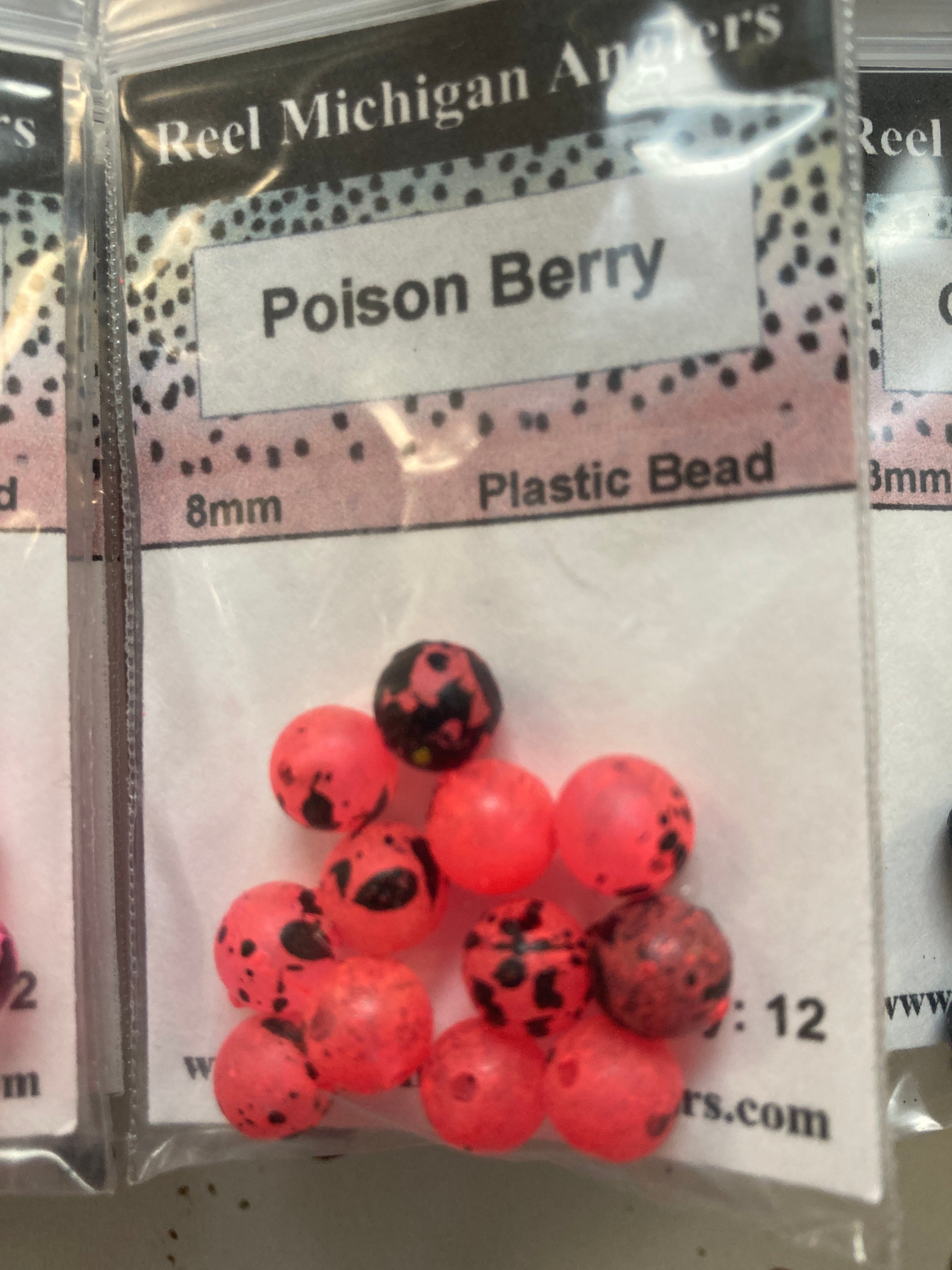 Red plastic bead pack with round beads and black speckles, 8mm label visible
